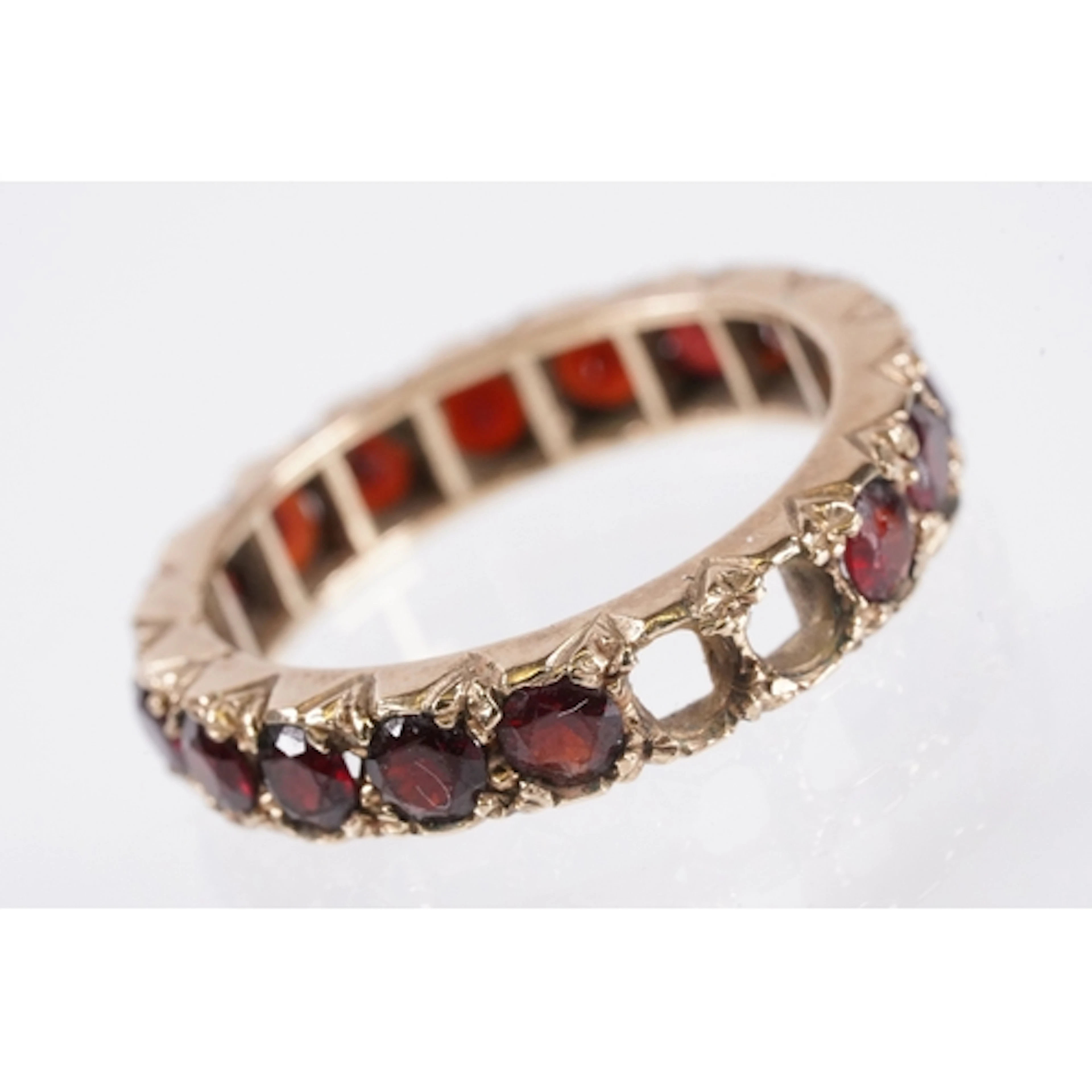 9ct gold and garnet full eternity ring being set with round ...