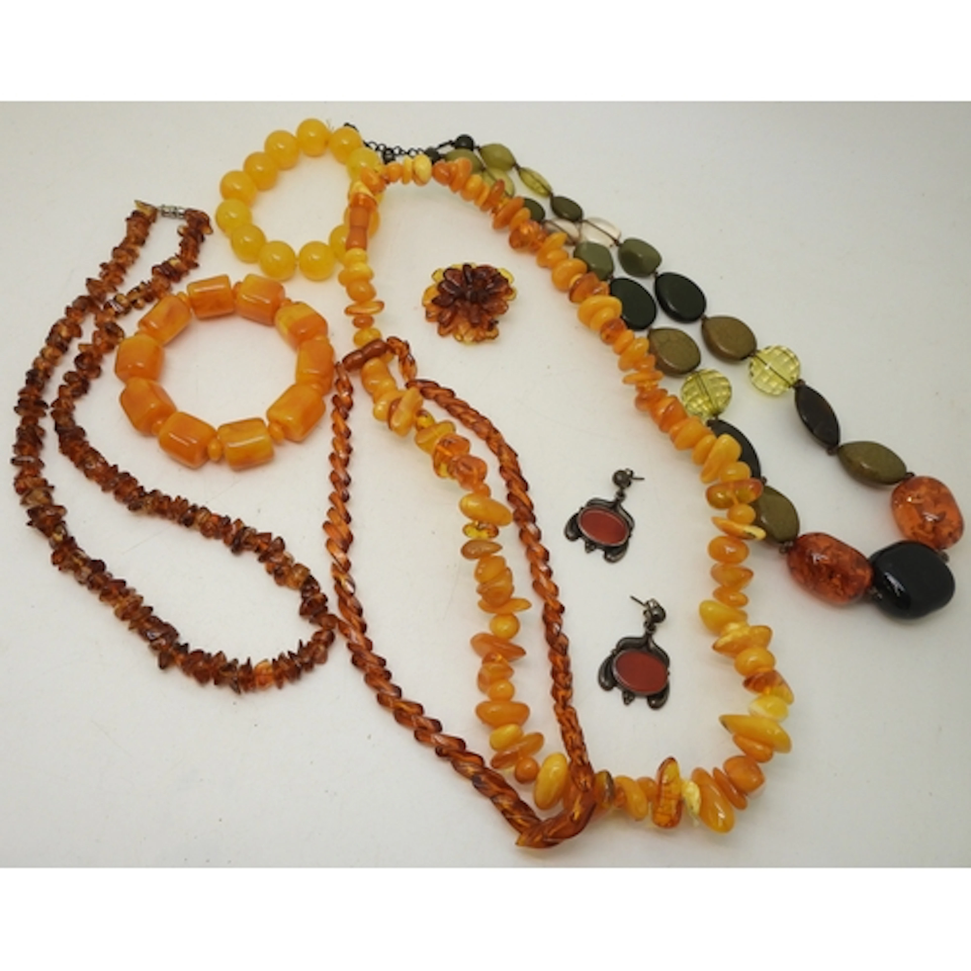 Two strings of amber coloured beads, a carnelian bead neckla...