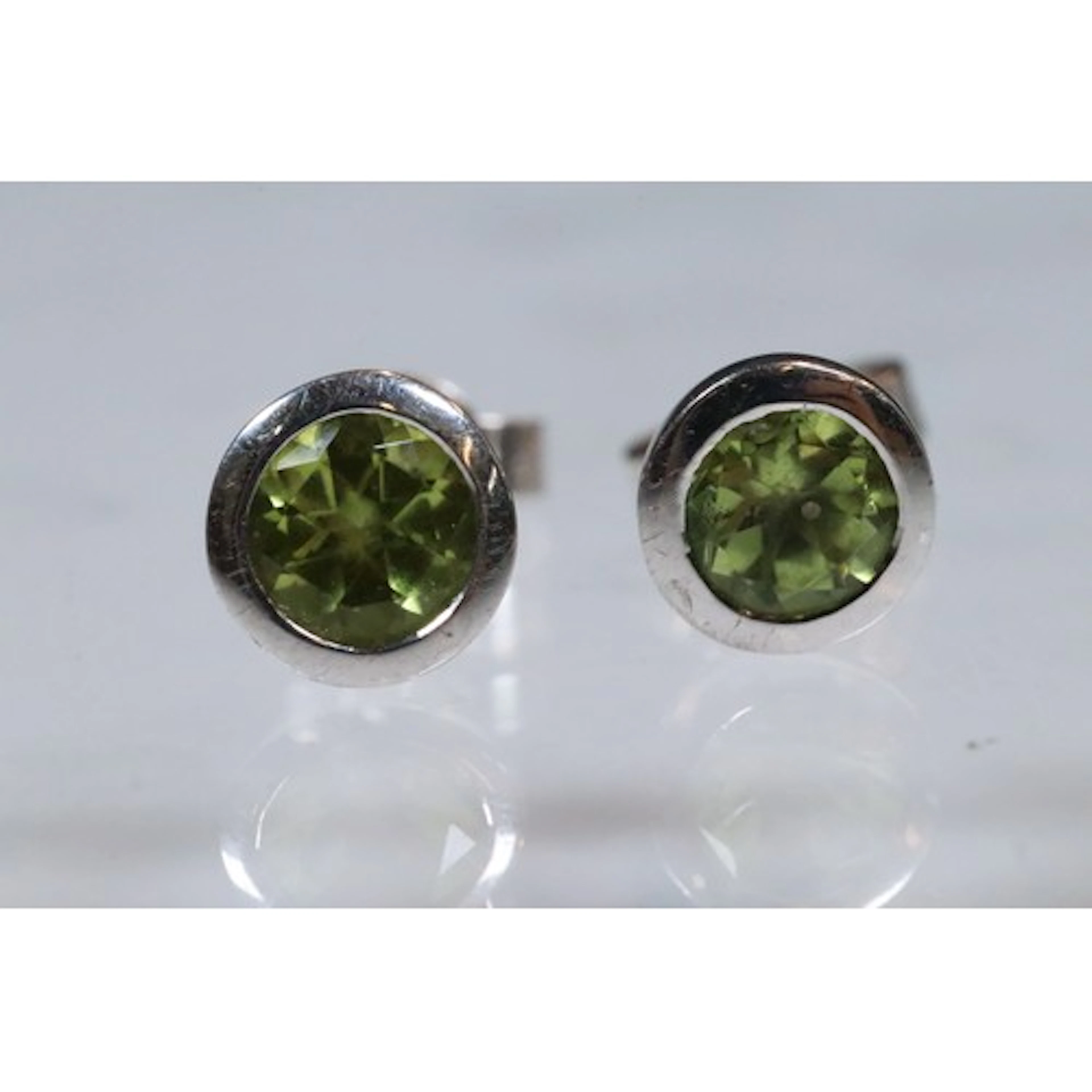 18ct white gold and peridot stud earrings. The stud earrings...