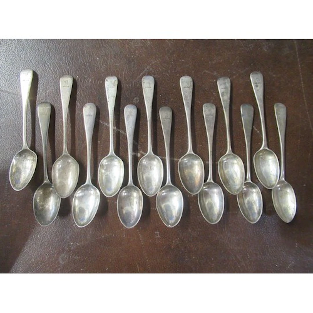 A set of 14 silver tea spoons, engraved with a crest, weight...