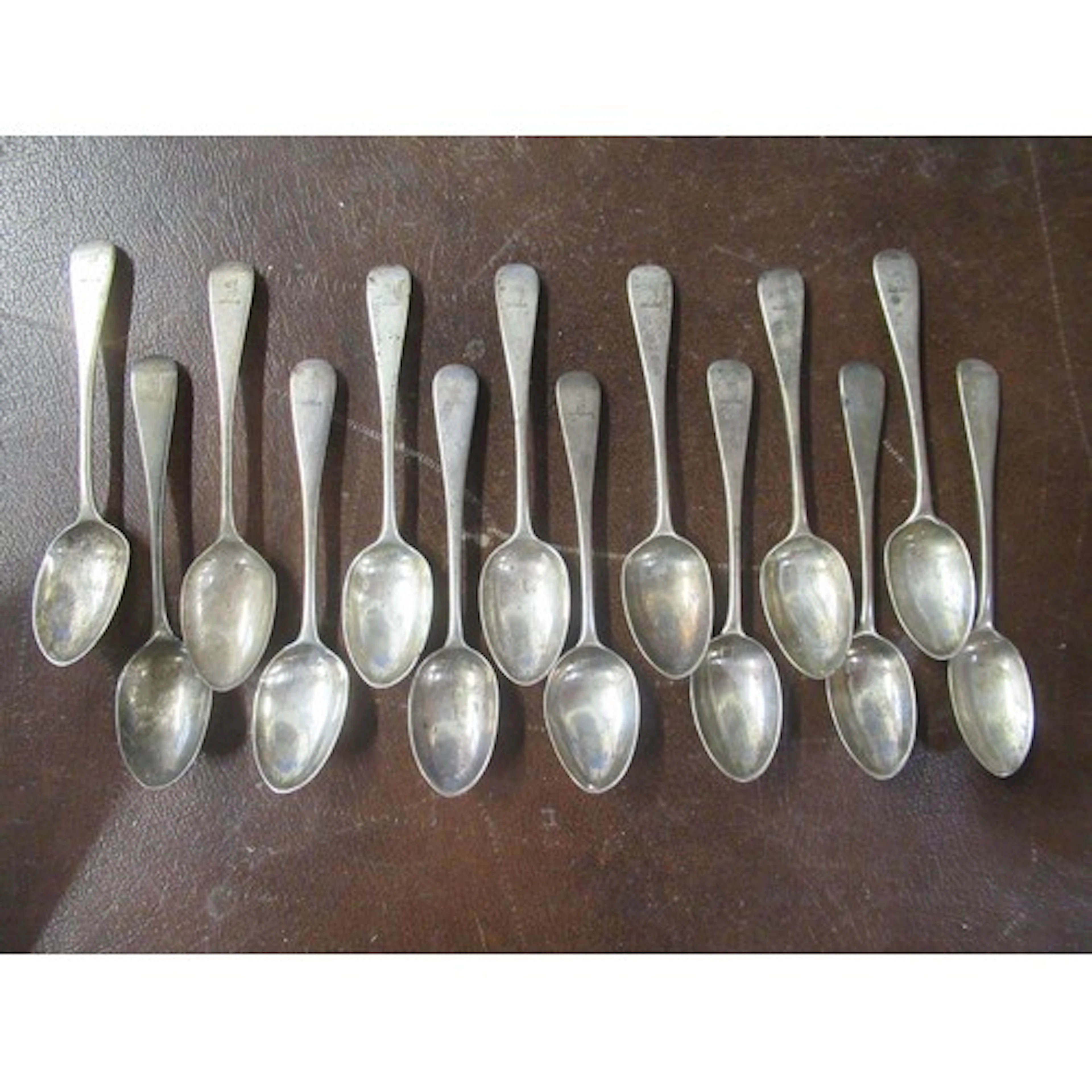 A set of 14 silver tea spoons, engraved with a crest, weight...