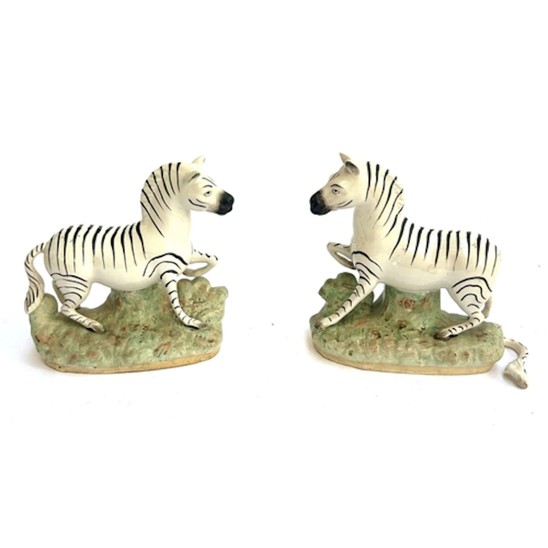 A pair of 19th century Staffordshire Zebras, (one with detac...