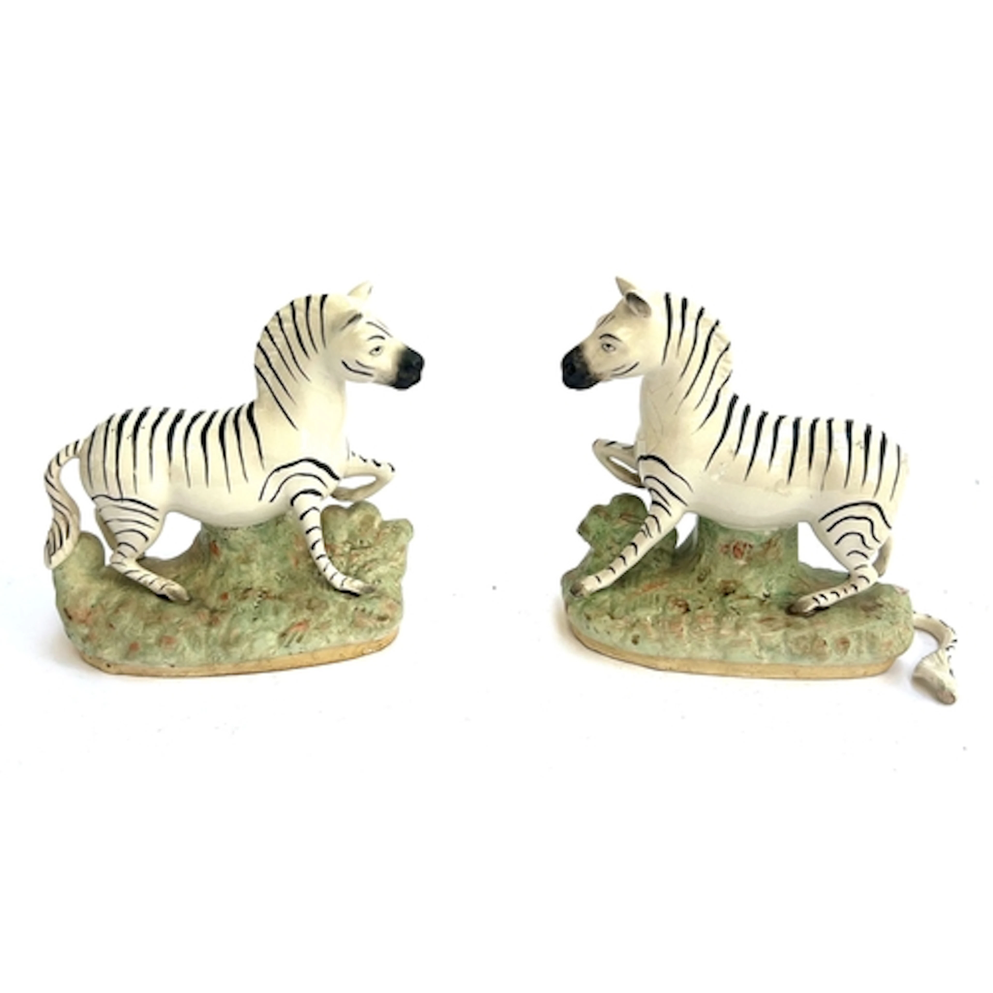 A pair of 19th century Staffordshire Zebras, (one with detac...