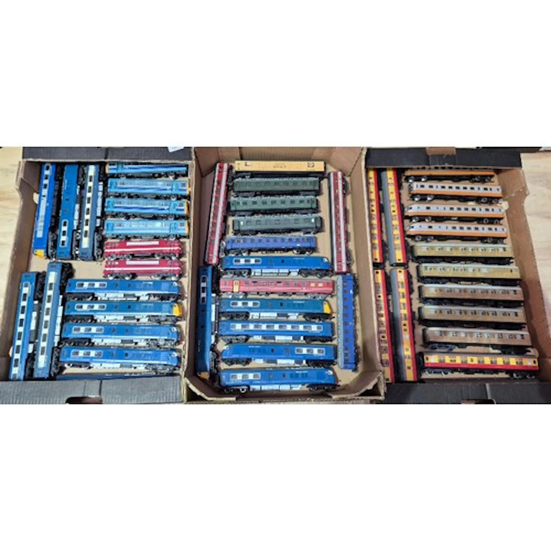Three boxes of assorted model train coaches.
