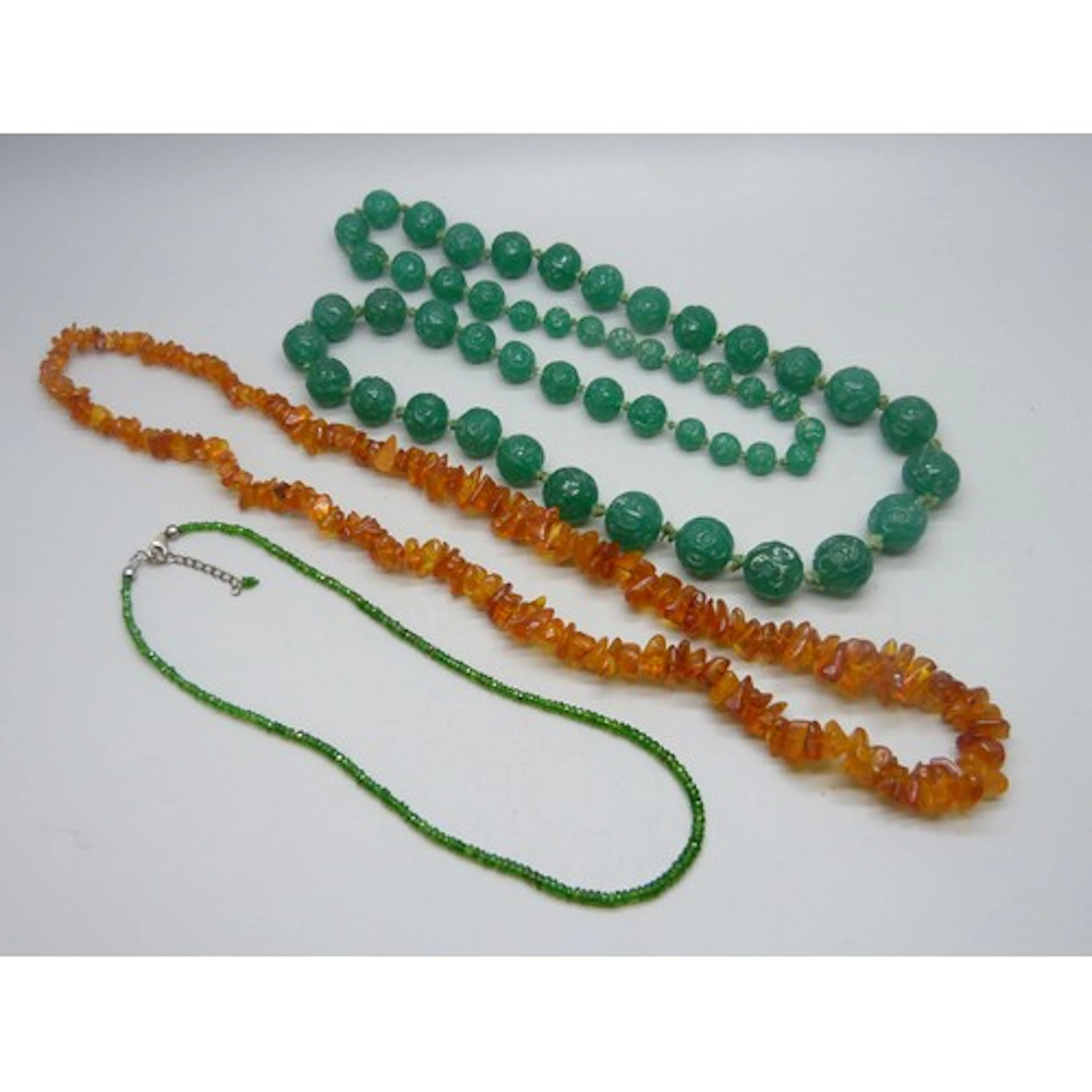 A large vintage carved glass bead necklace, an amber necklac...