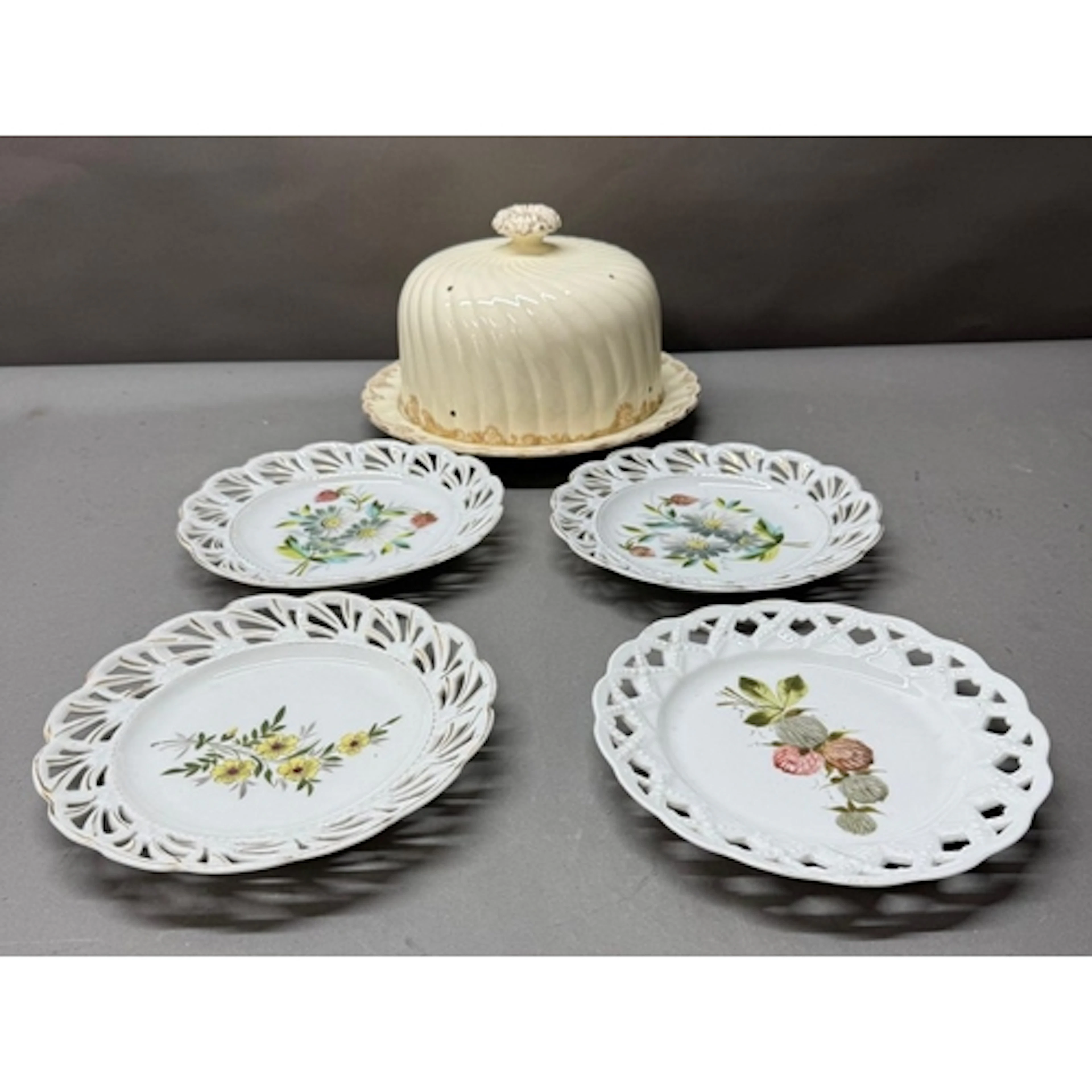 Four white pierced side plates together with an ivory white ...