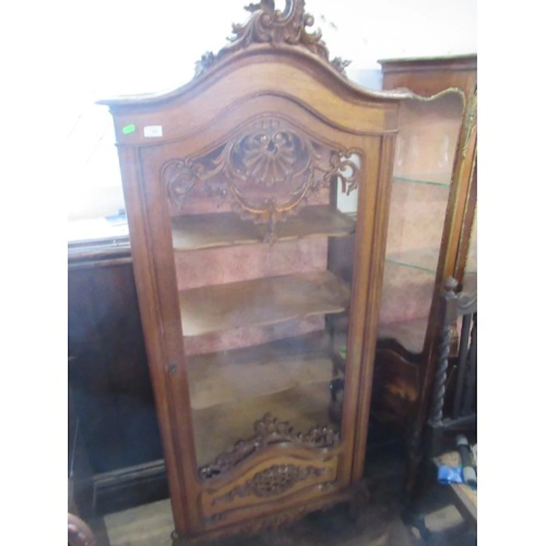 A continental style glazed cabinet with carved decoration wi...
