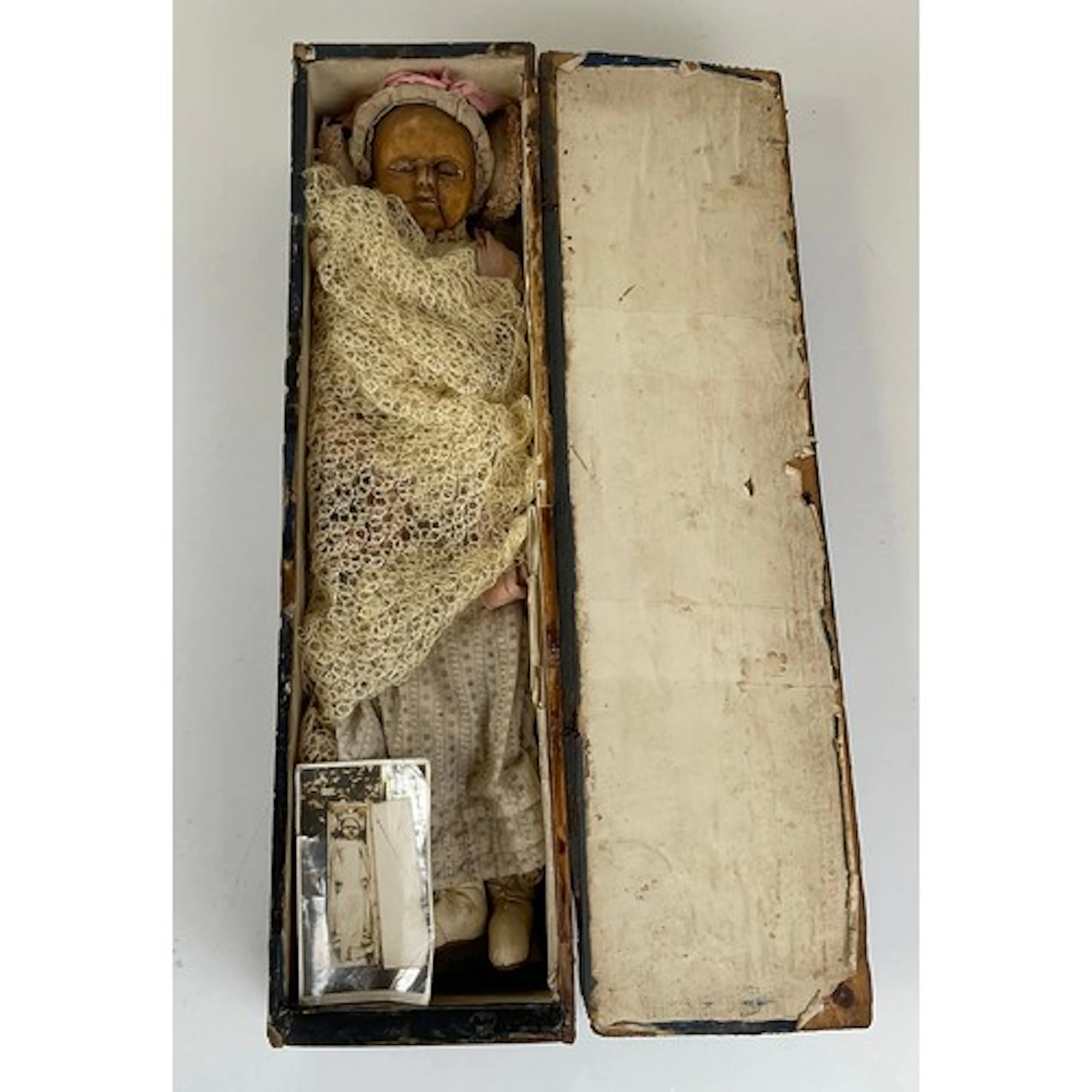 A 19th century wax head and shoulder doll, glass eyes, stuff...