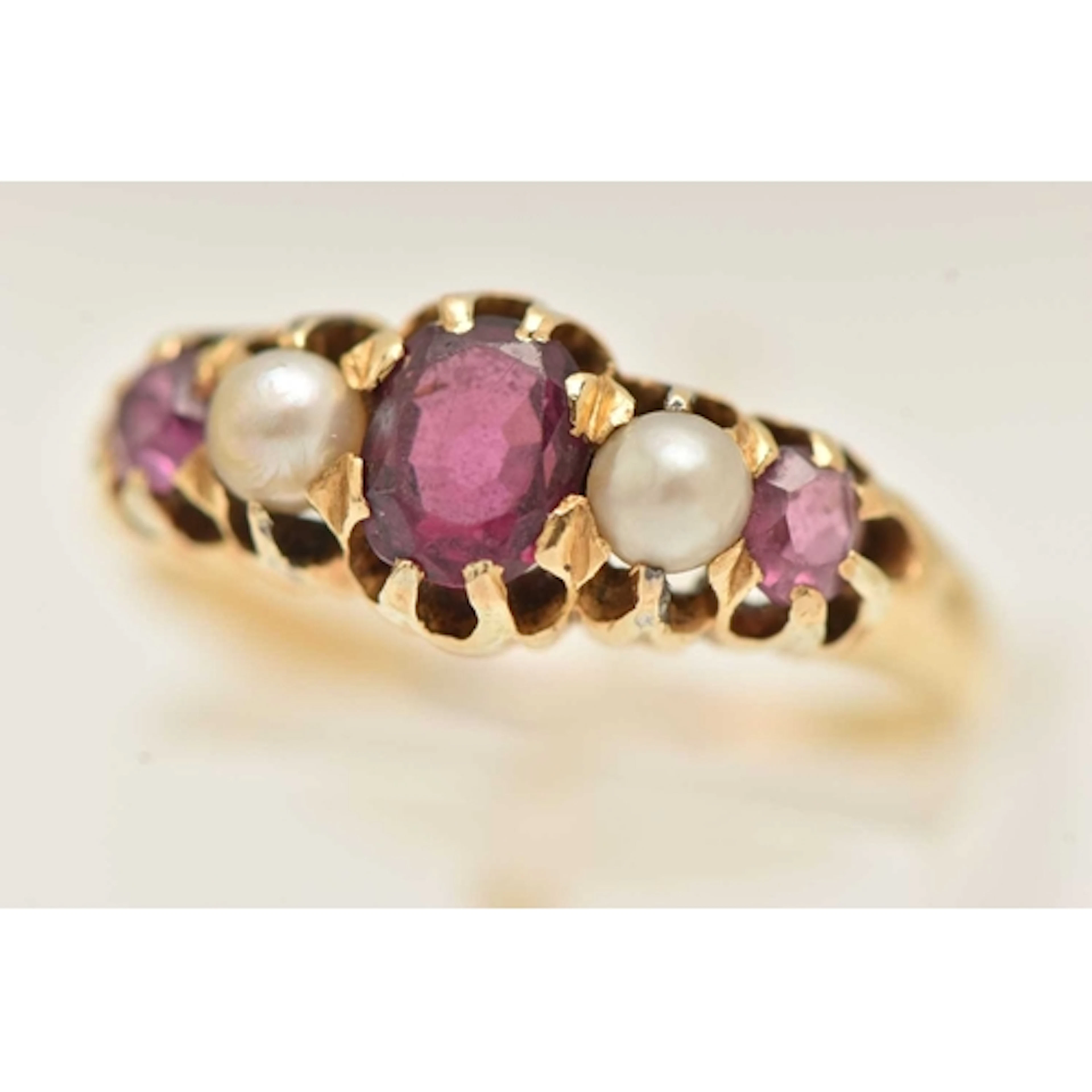 A YELLOW METAL AMETHYST AND SEED PEARL RING, set with an ova...
