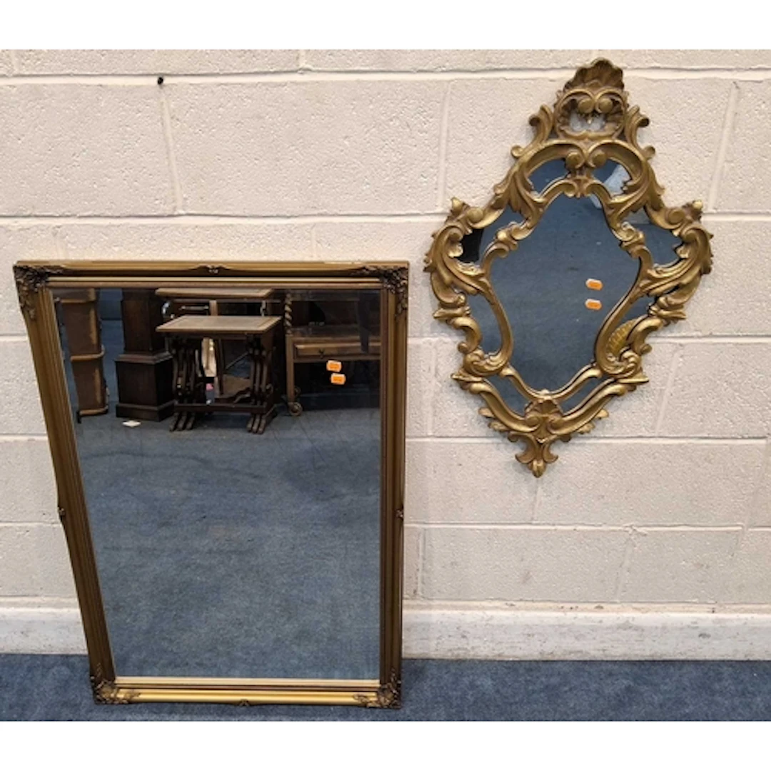 A GILT WOOD RECTANGULAR BEVELED EDGE WALL MIRROR, with scrol...
