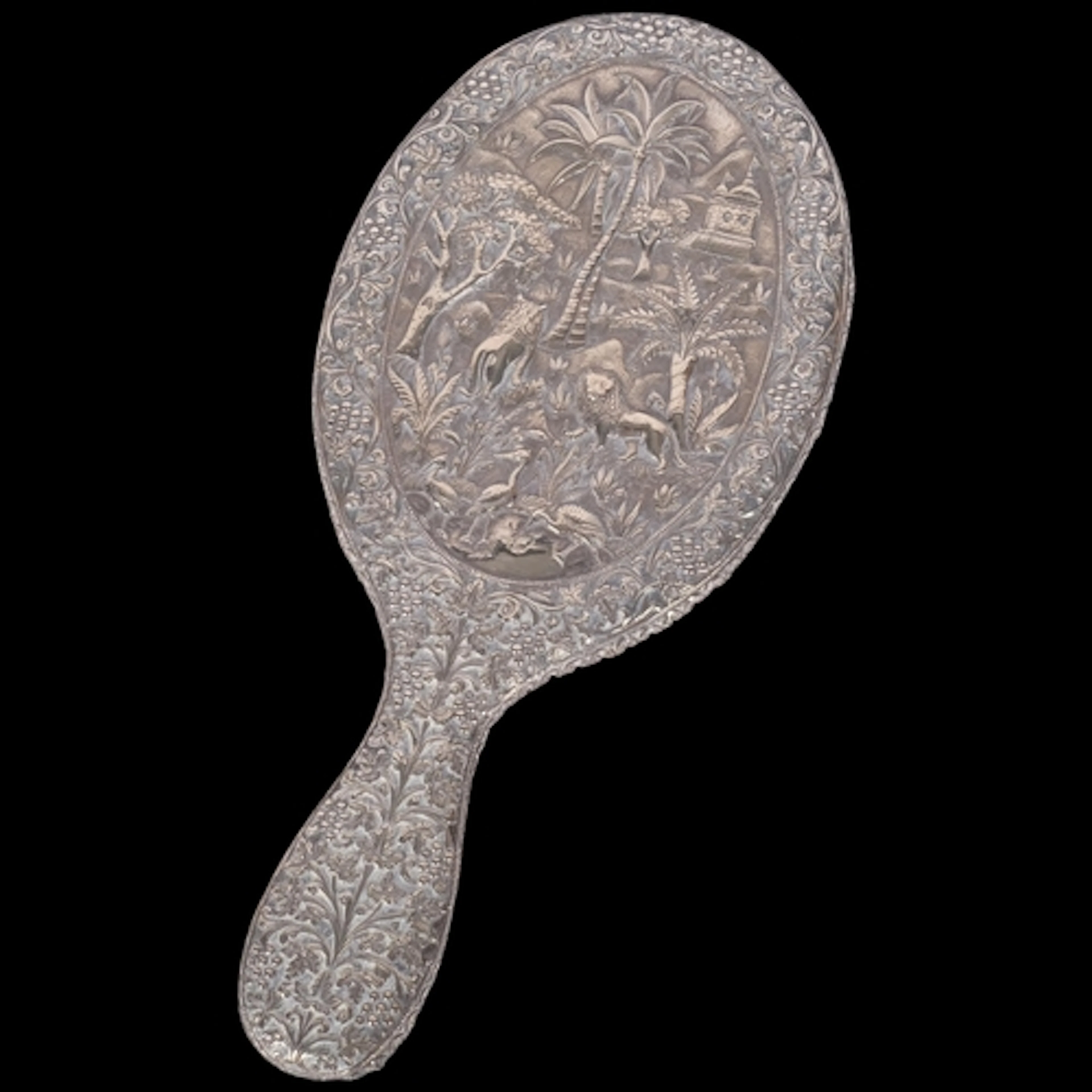 A large Indian white metal covered hand mirror, with high re...