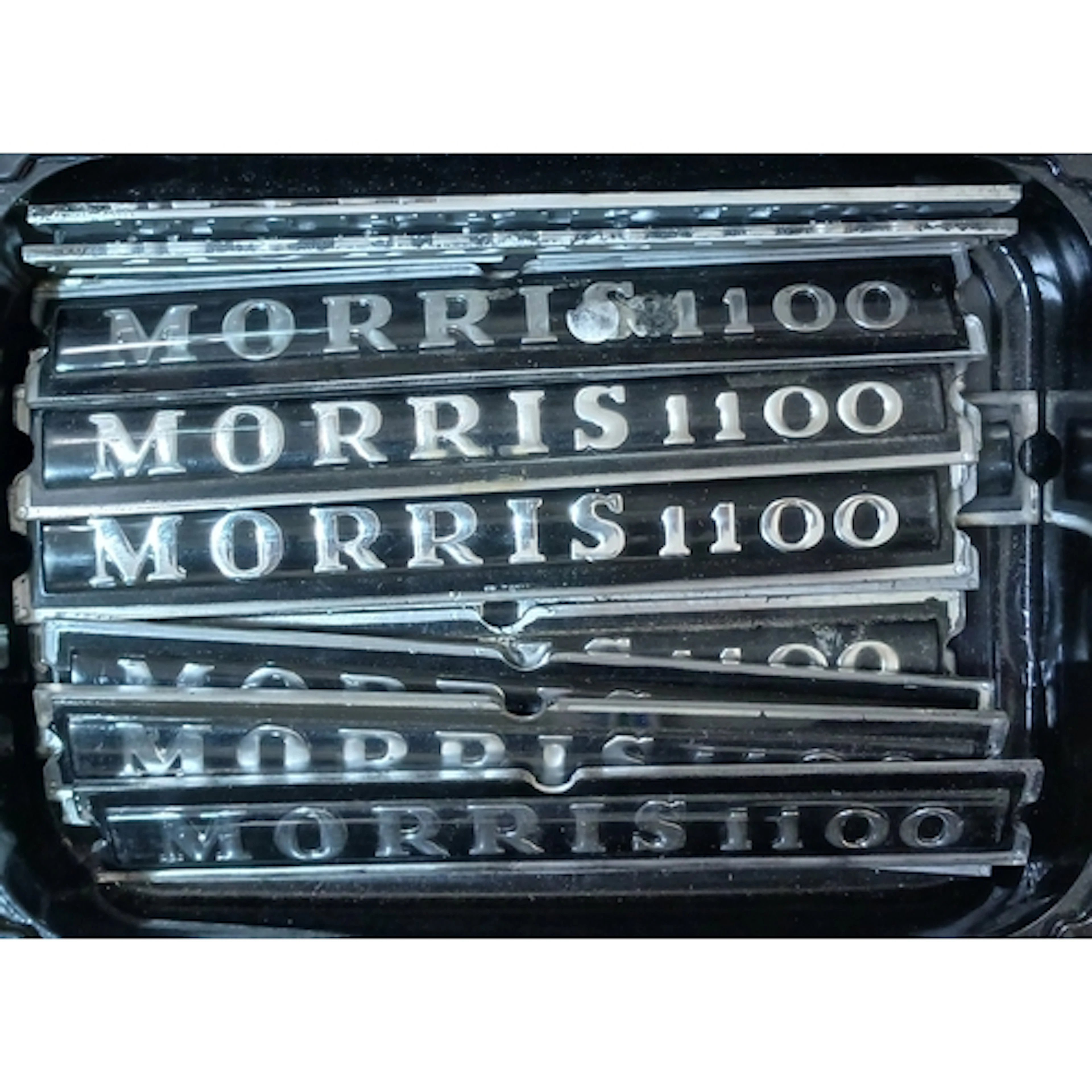 A box of assorted classic car badges.