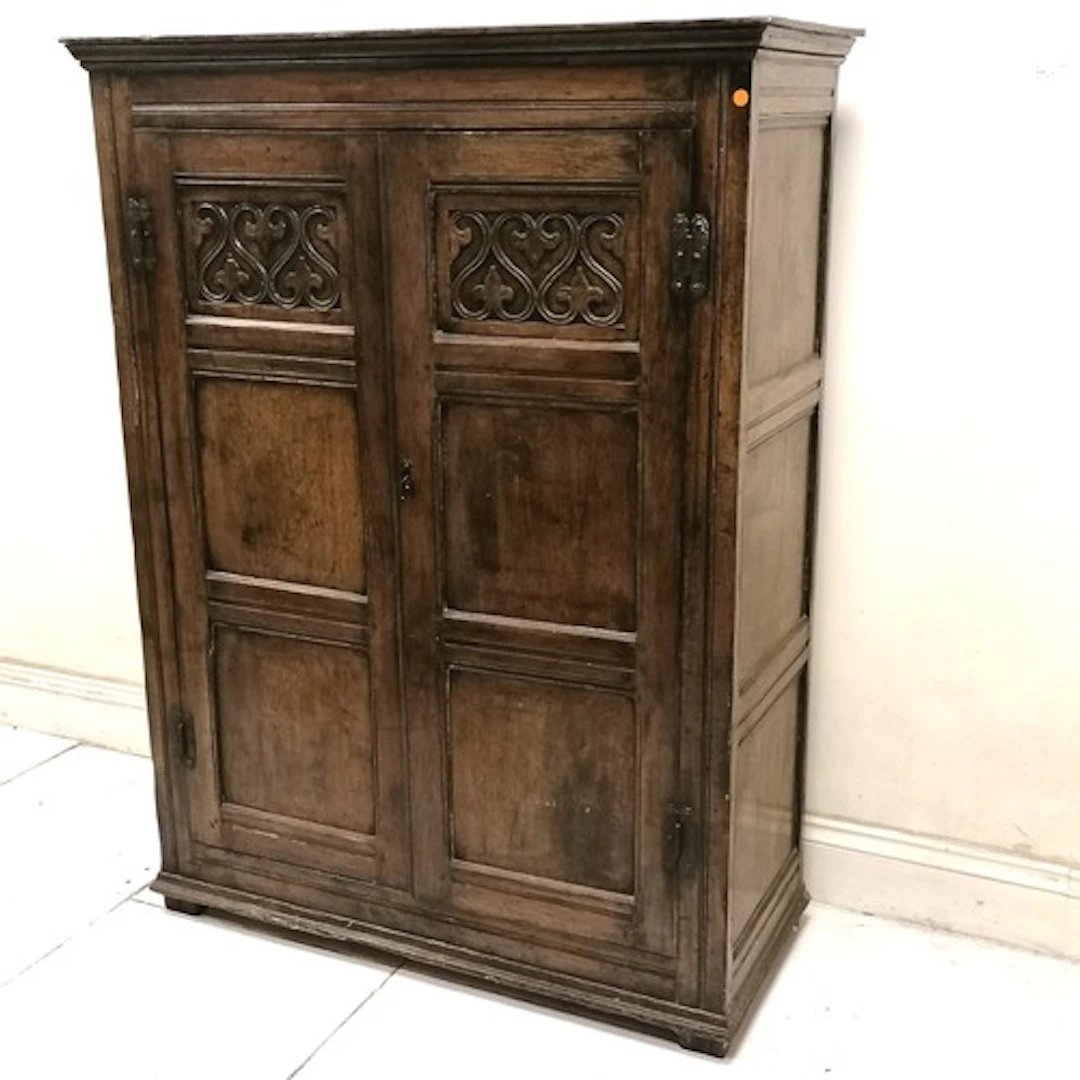 Antique oak 2 door hall cupboard with carved detail to the t...