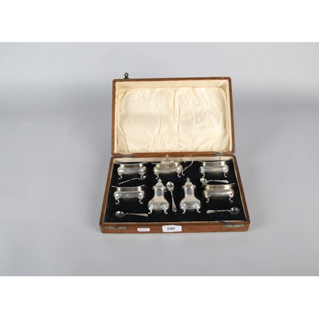 Set of silver condiment pots with blue liners, in fitted cas...