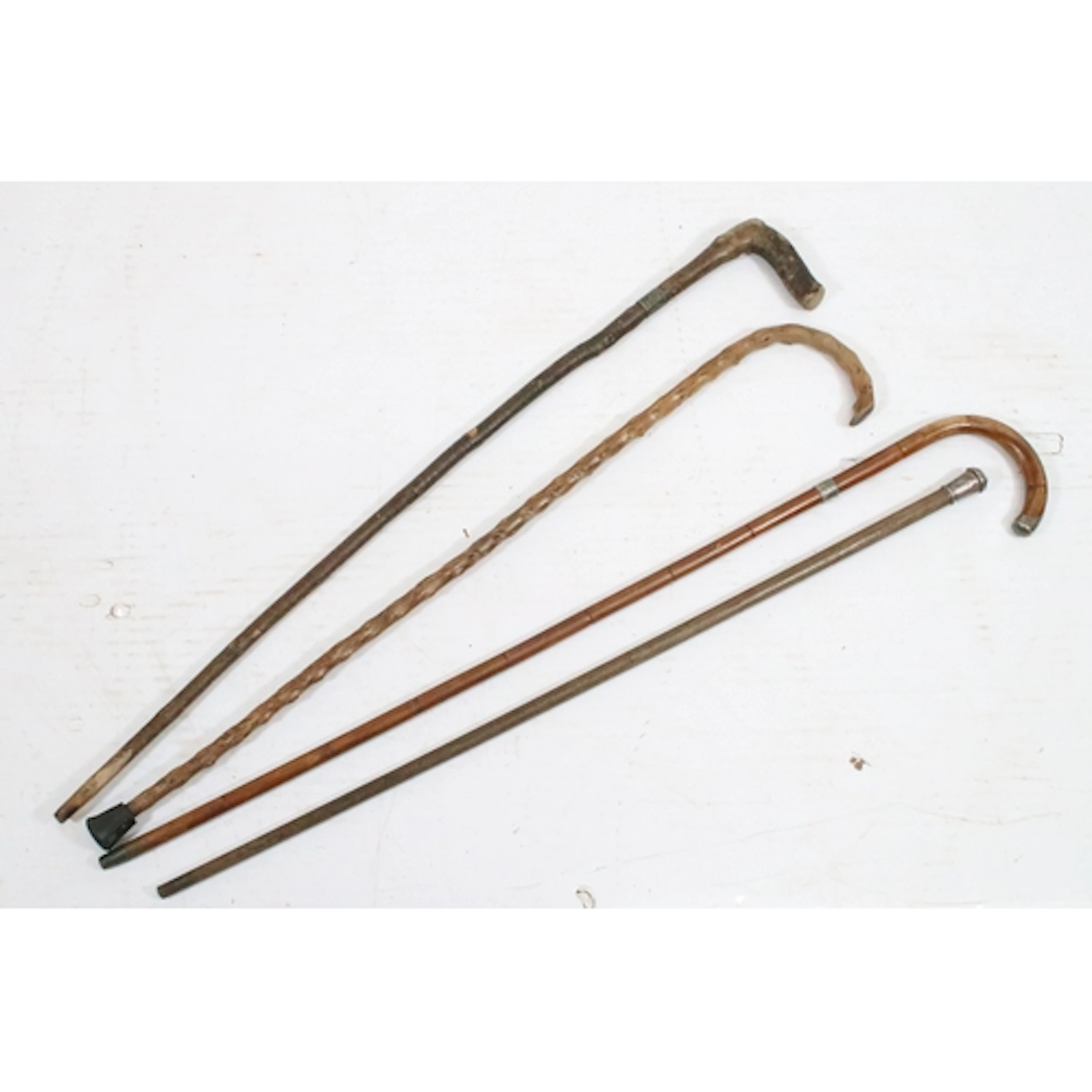 Group of four walking sticks, one with silver top marked for...