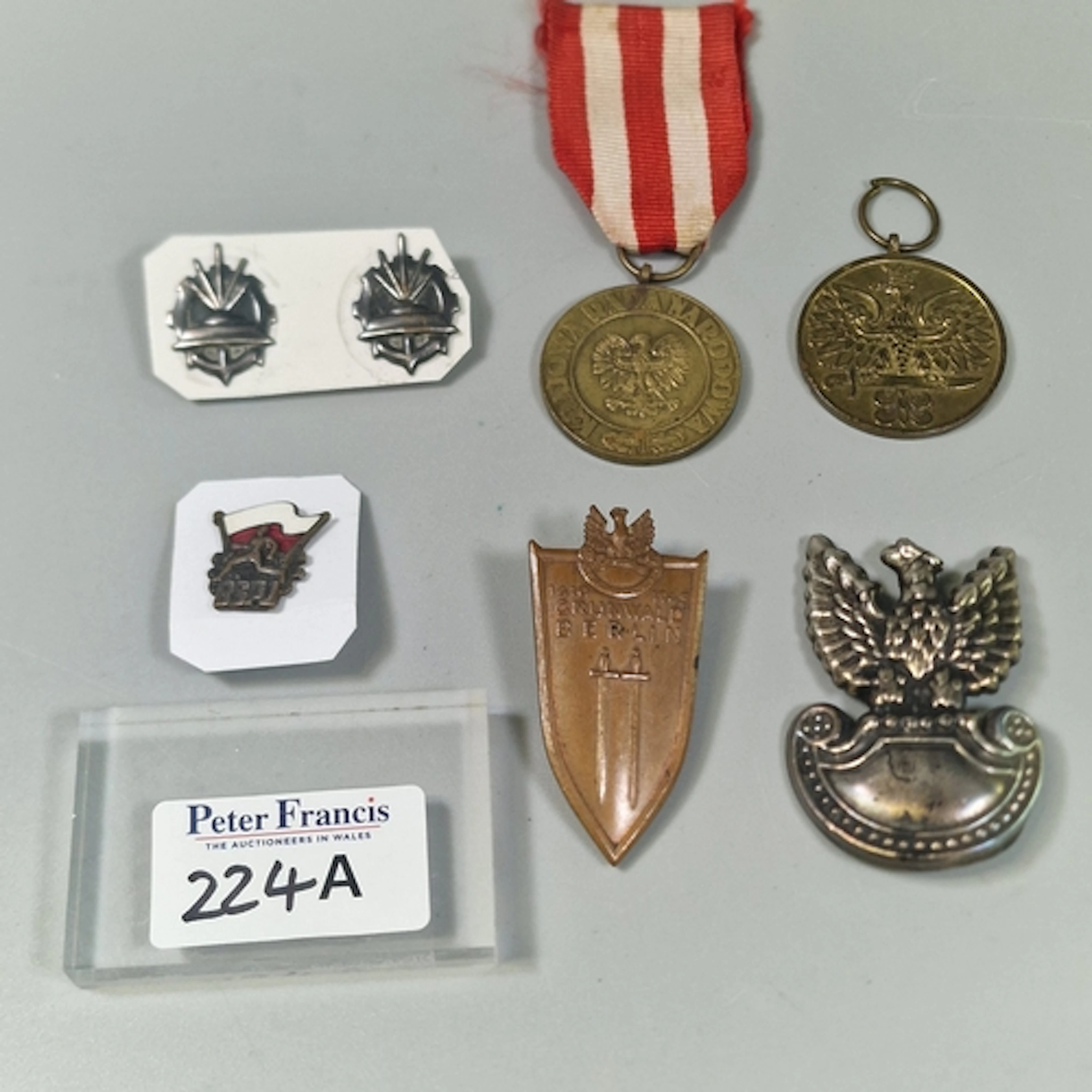 Collection of Polish militaria, including cap badges, a Grun...