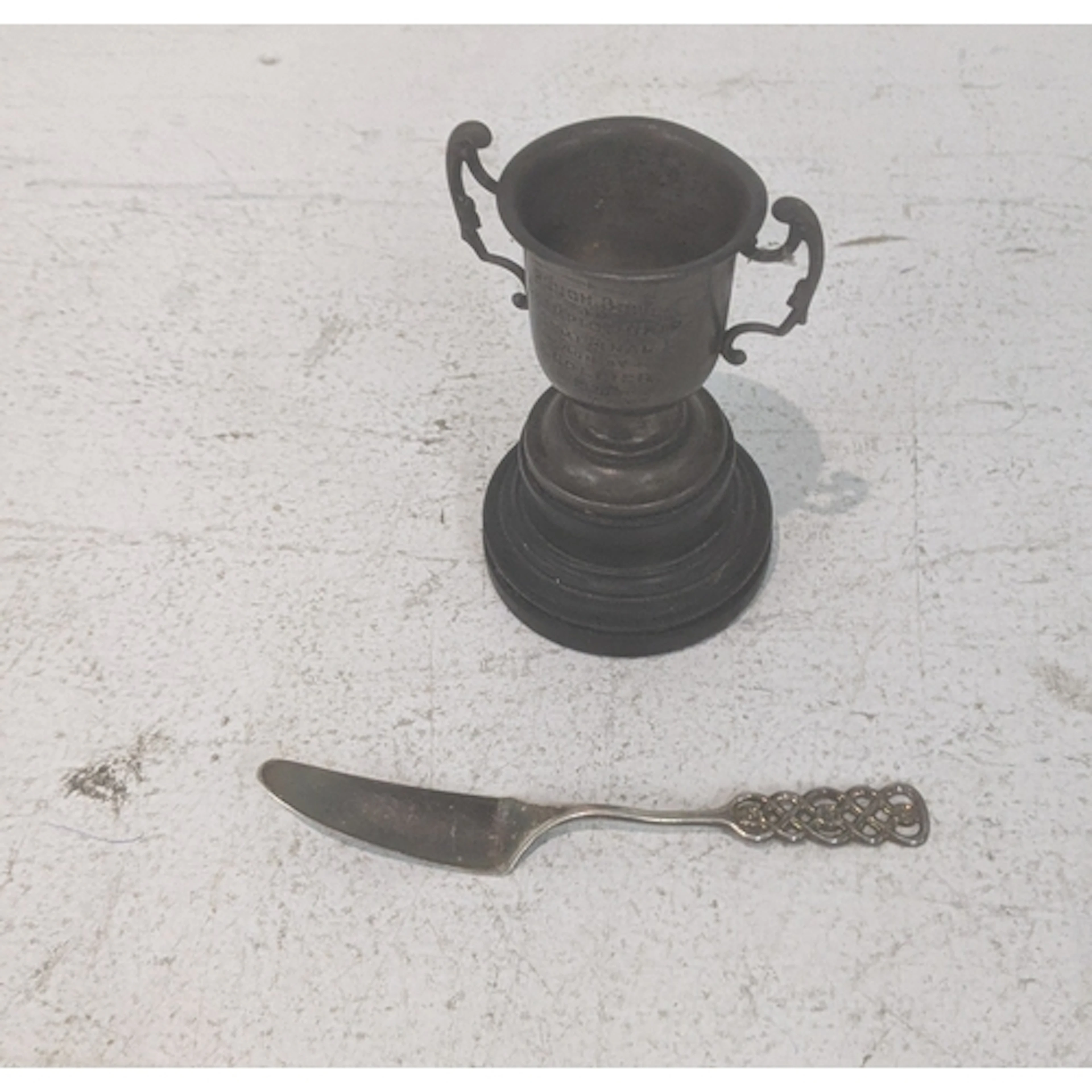 A silver twin handled trophy cup on a stand along with an 83...