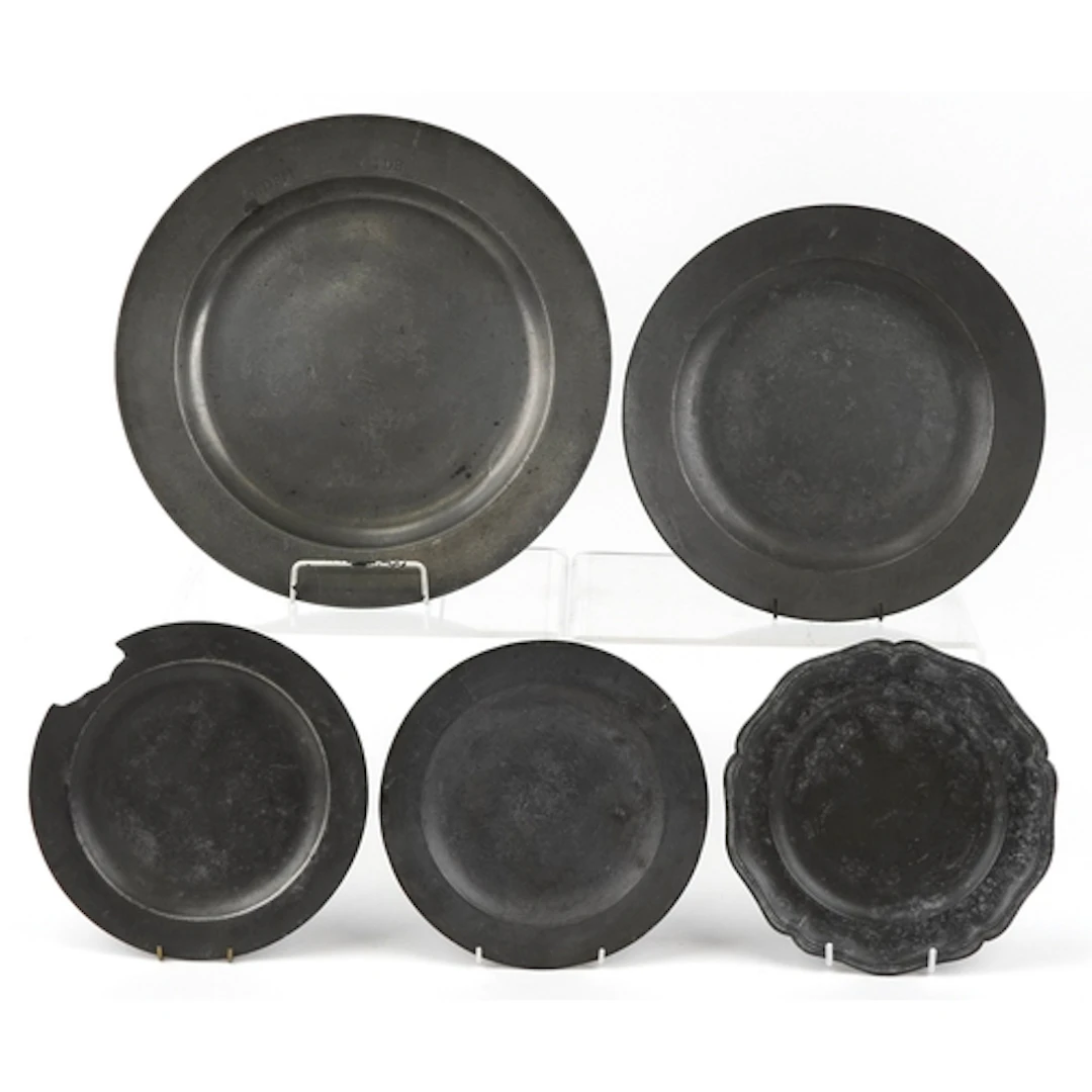 Five antique pewter plates, four with foundry marks, the lar...