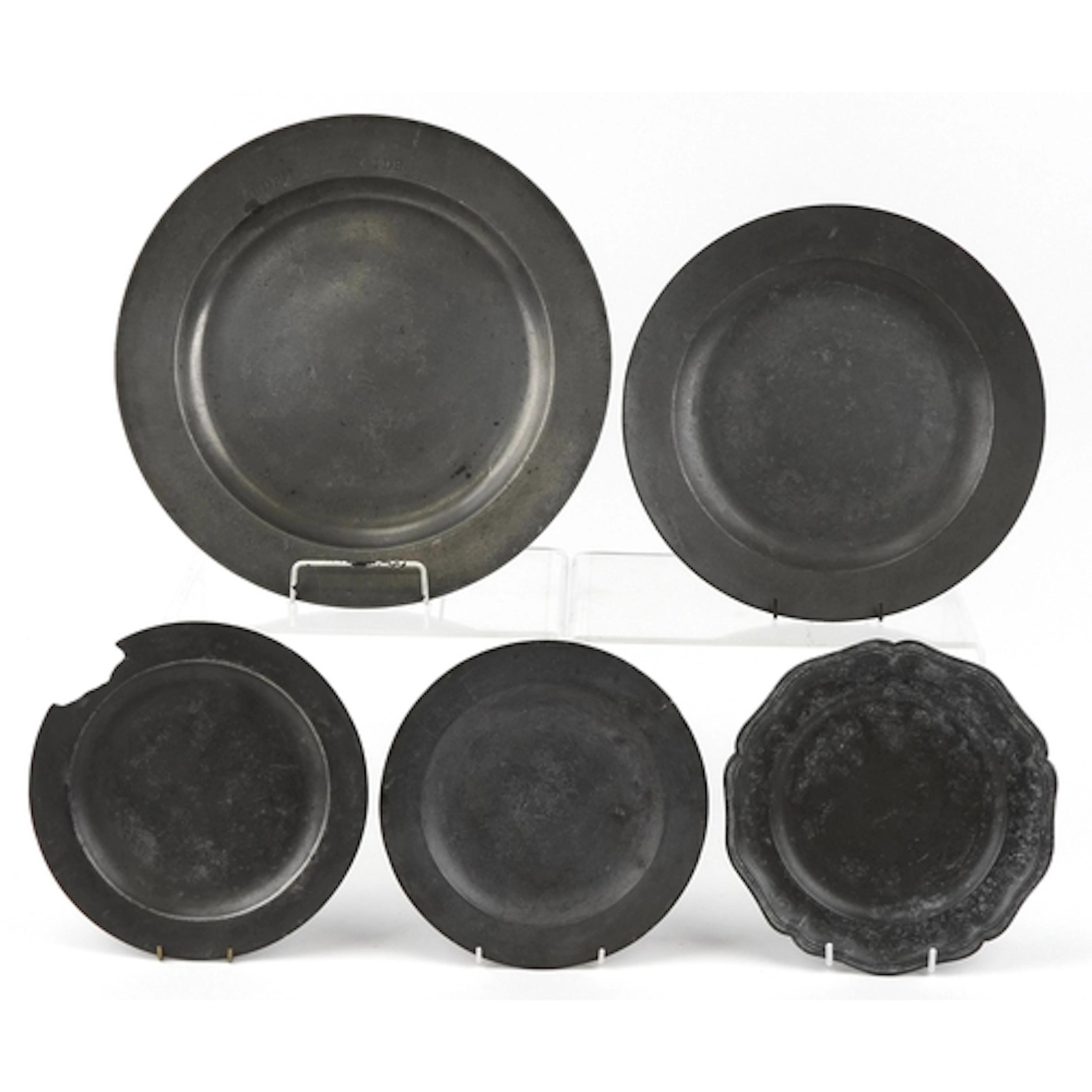 Five antique pewter plates, four with foundry marks, the lar...