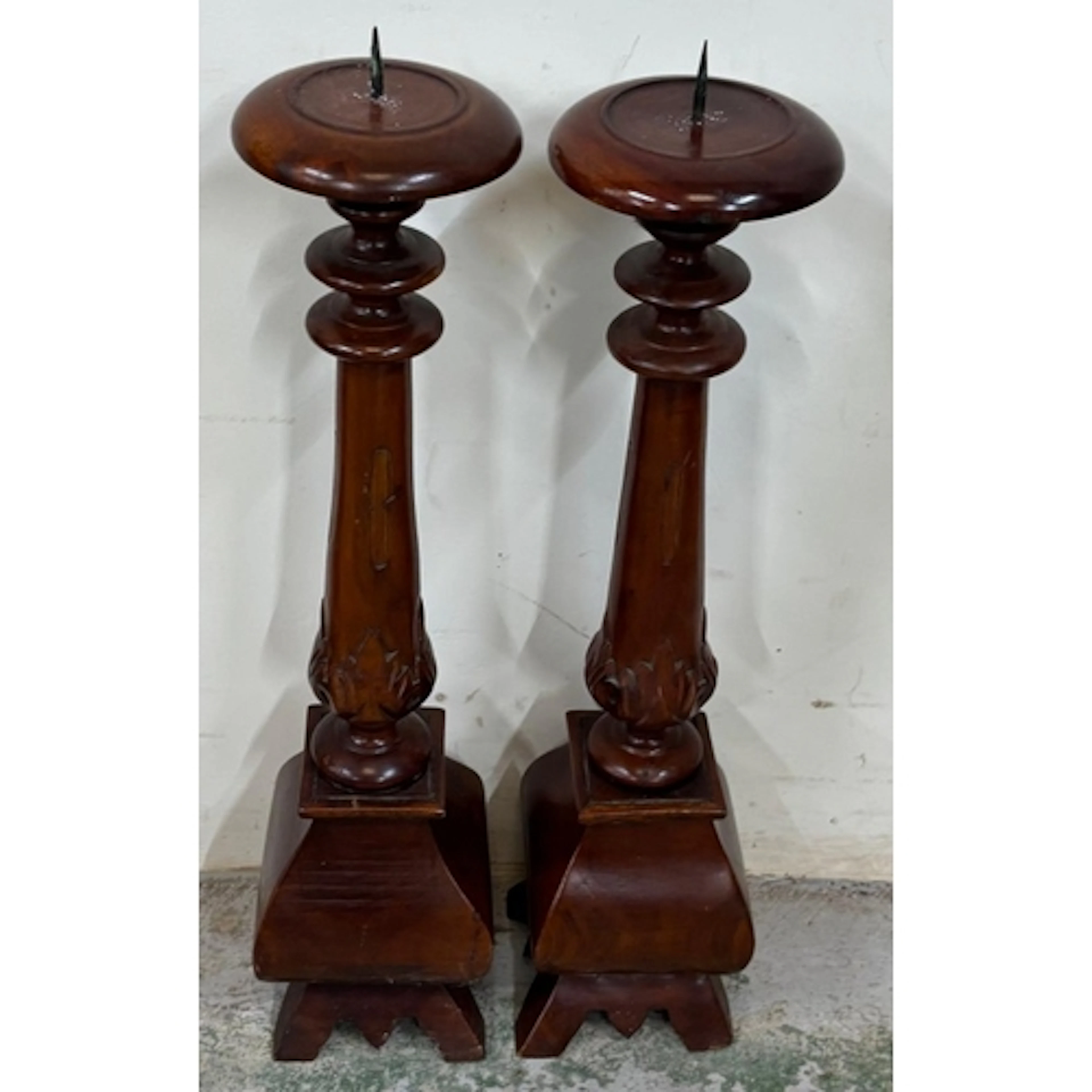 A pair of wooden candlesticks with turned baluster style sha...