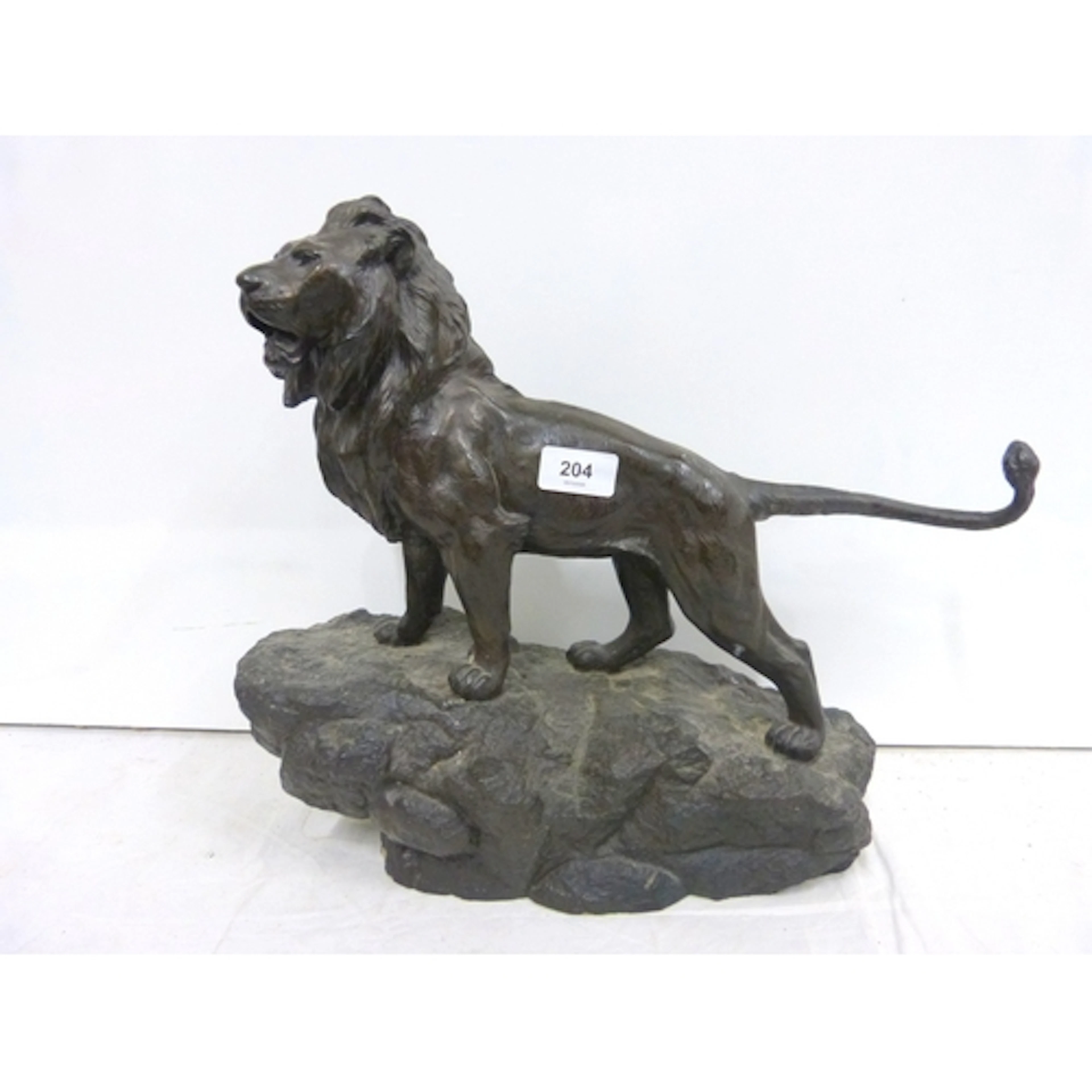 Large resin lion on a rock sculpture.
