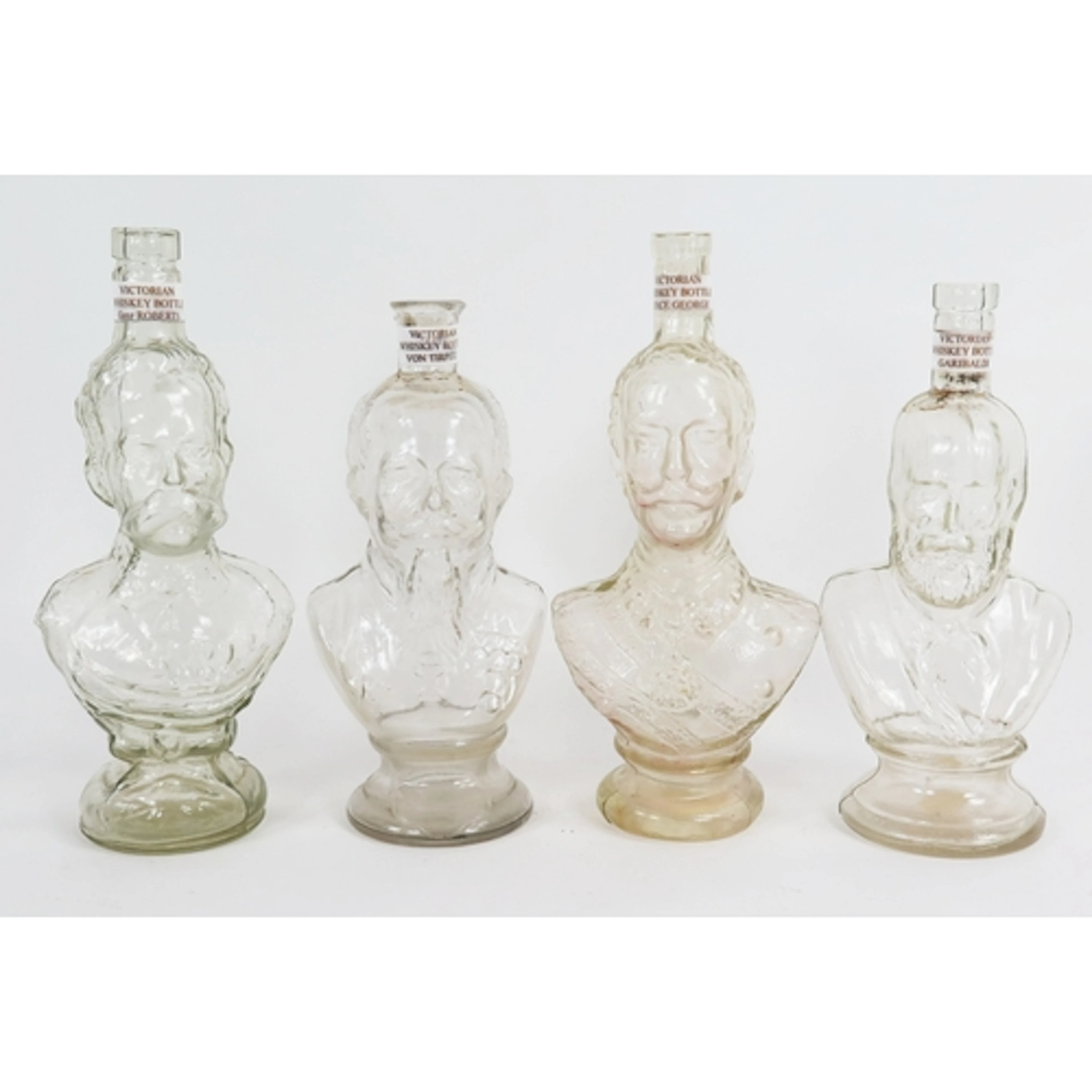 A set of four moulded glass character whiskey bottles, Princ...