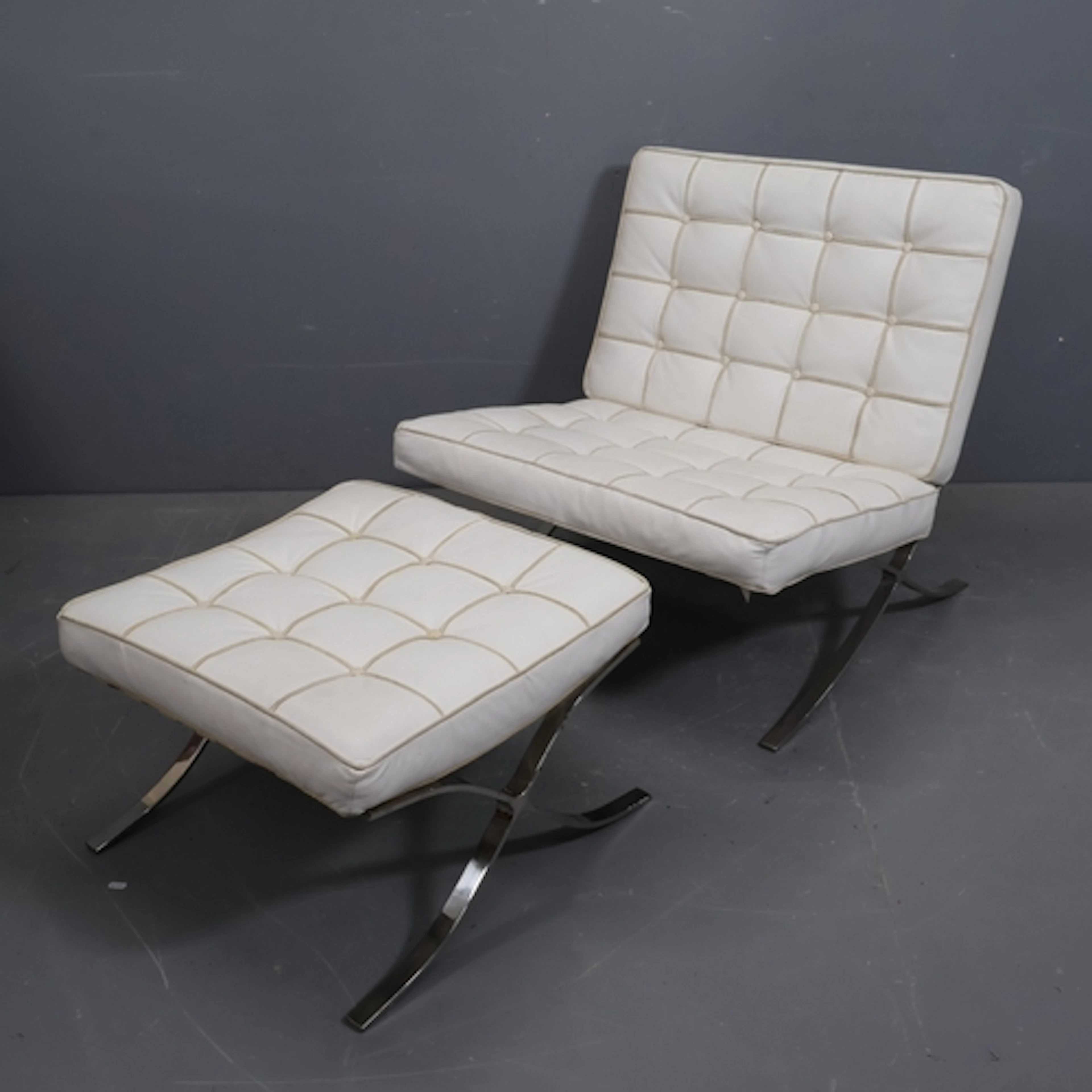 A Barcelona style faux white leather upholstered lounge chai...