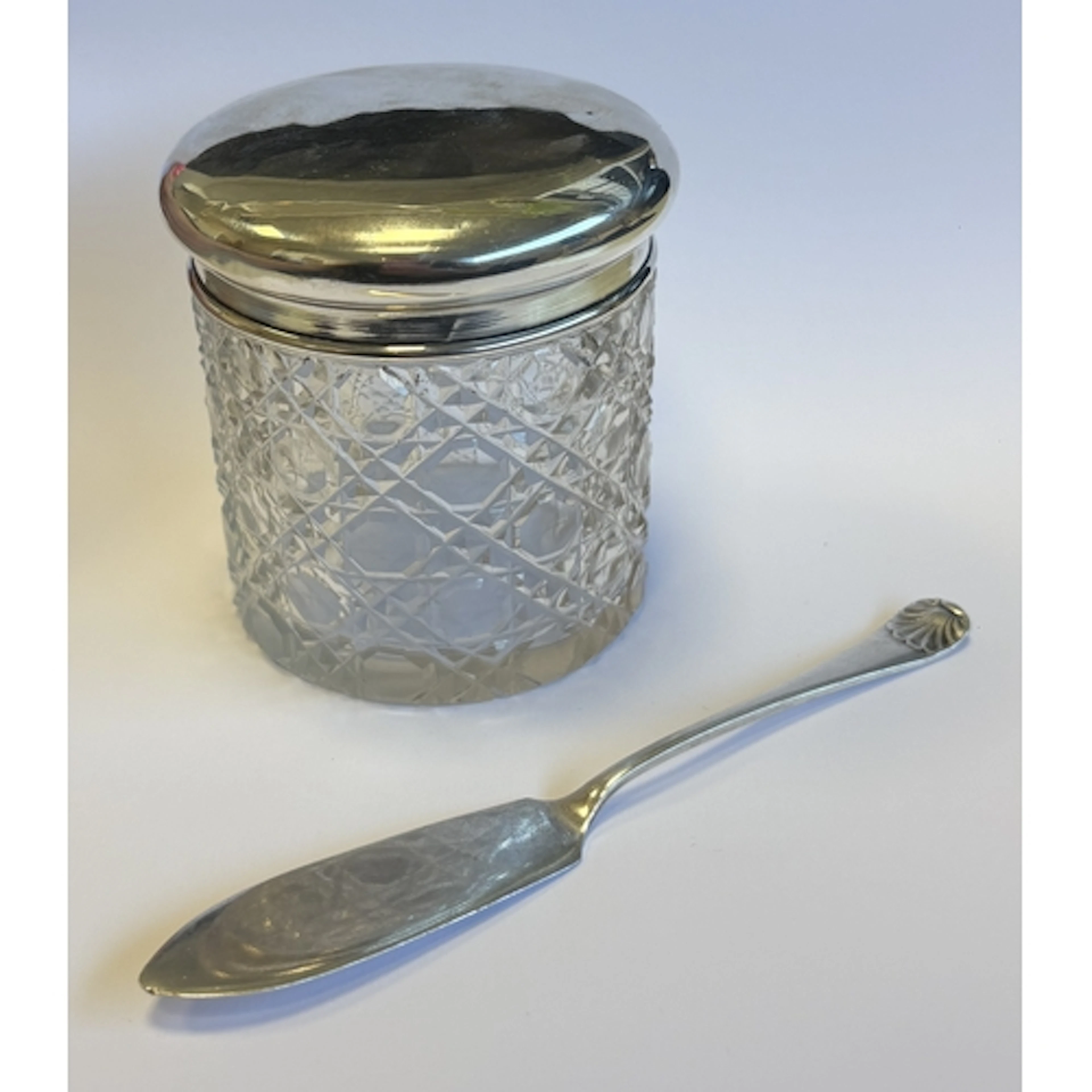 A silver-lidded glass dressing table jar together with a sil...
