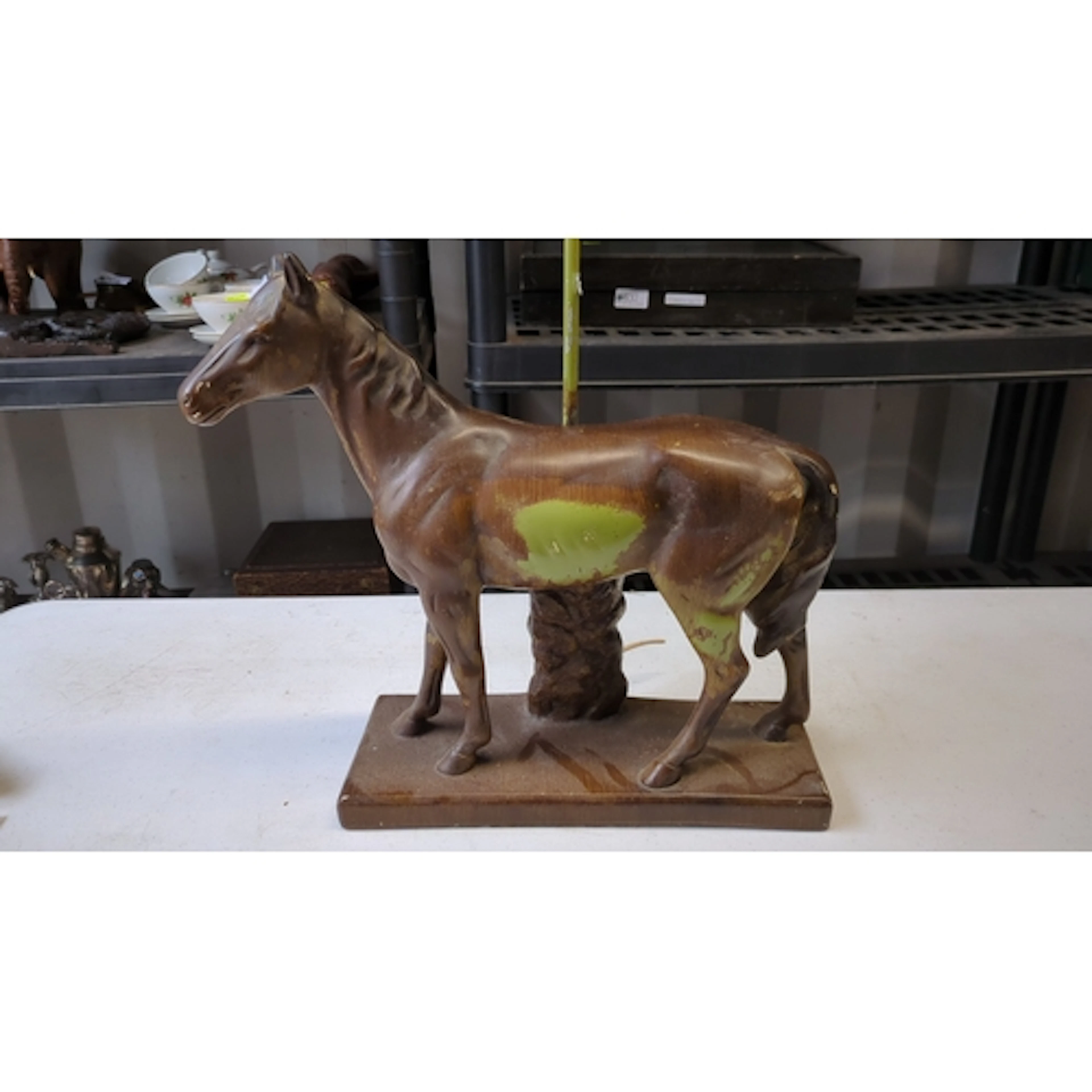 Metal table lamp modelled as a standing horse beside a rocky...