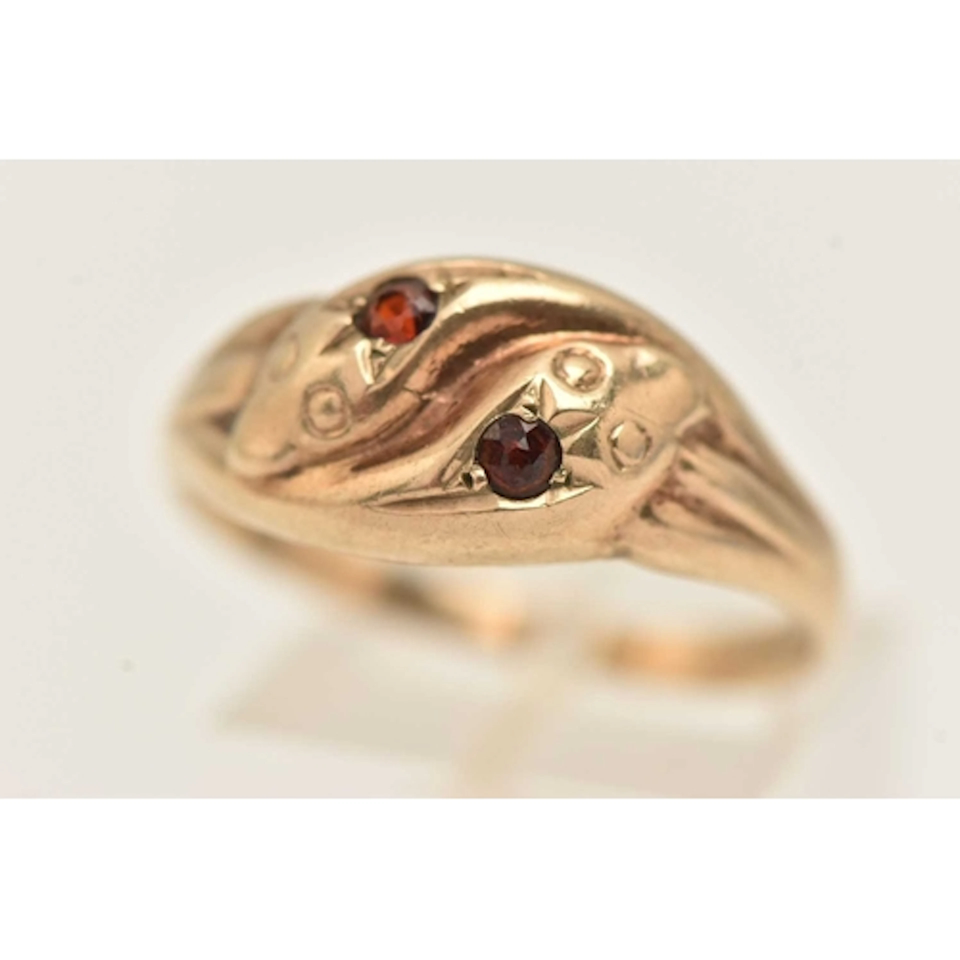 A 9CT GOLD DOUBLE SNAKE RING, set with two small circular cu...