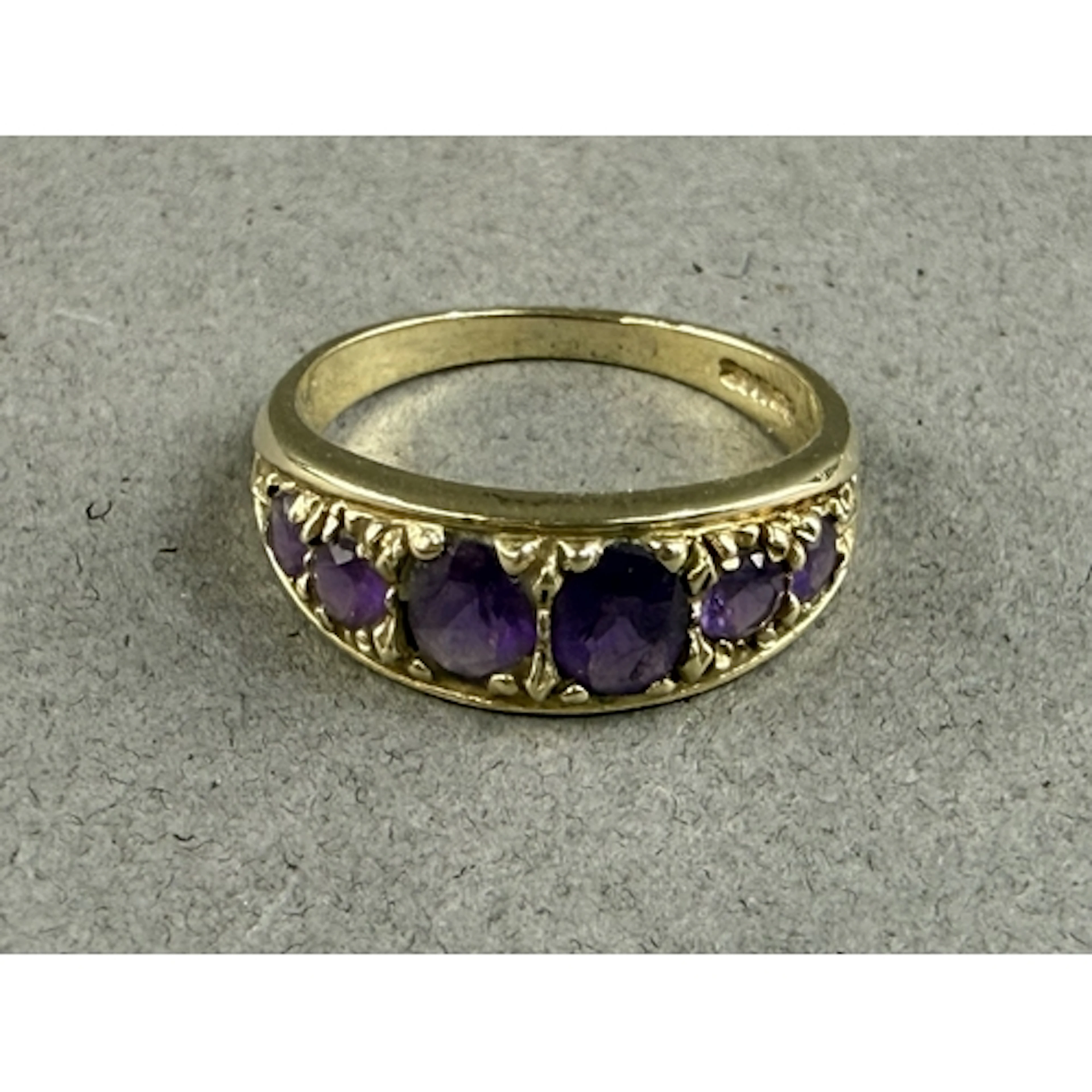 Jewellery: a 9ct yellow gold ring set with six graduated ame...