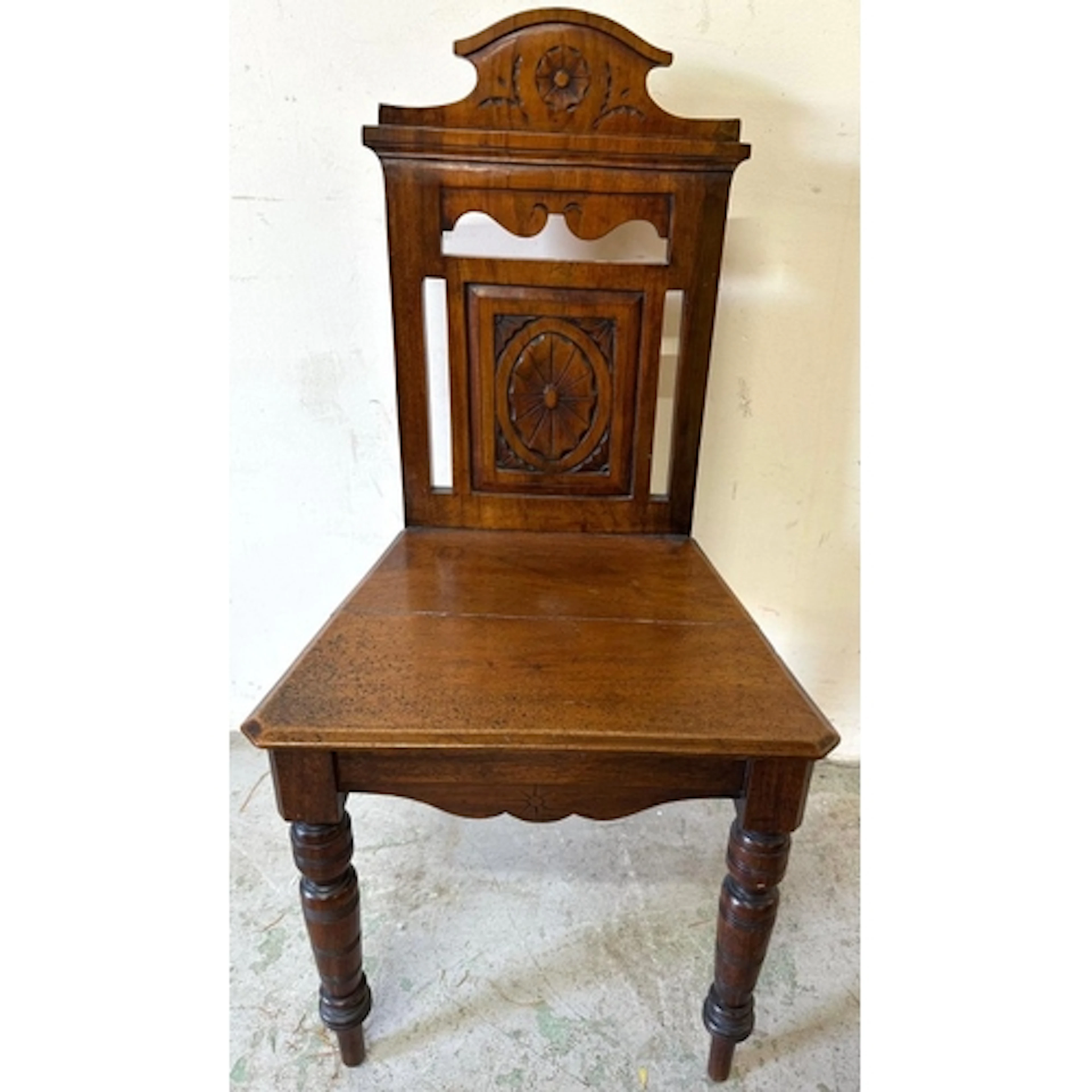 A Victorian style hall chair with floral carving and ring tu...
