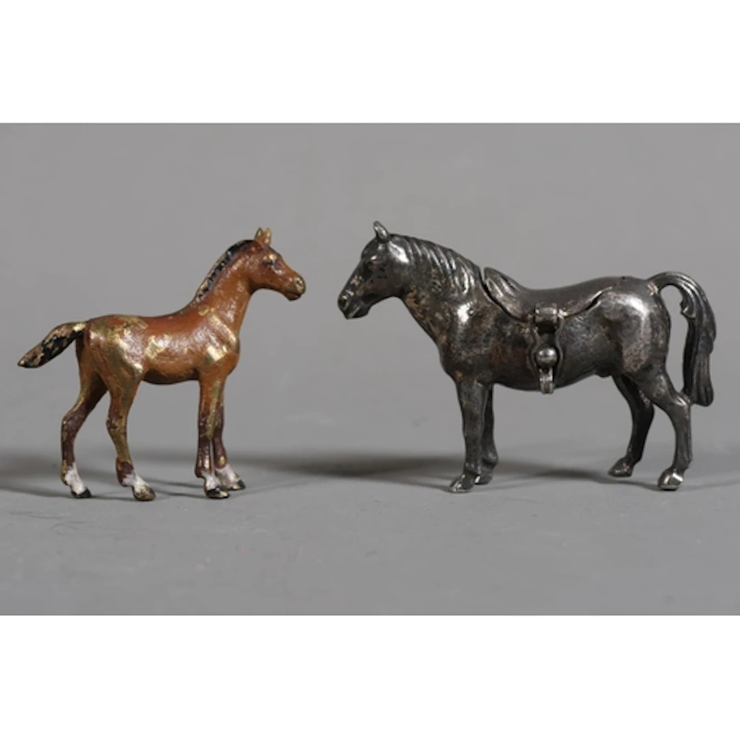 Two miniature models of horses one with an opening saddle an...