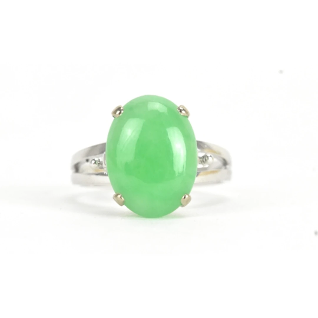 A jade 18ct white gold dress ring, the oval jade cabochon in...