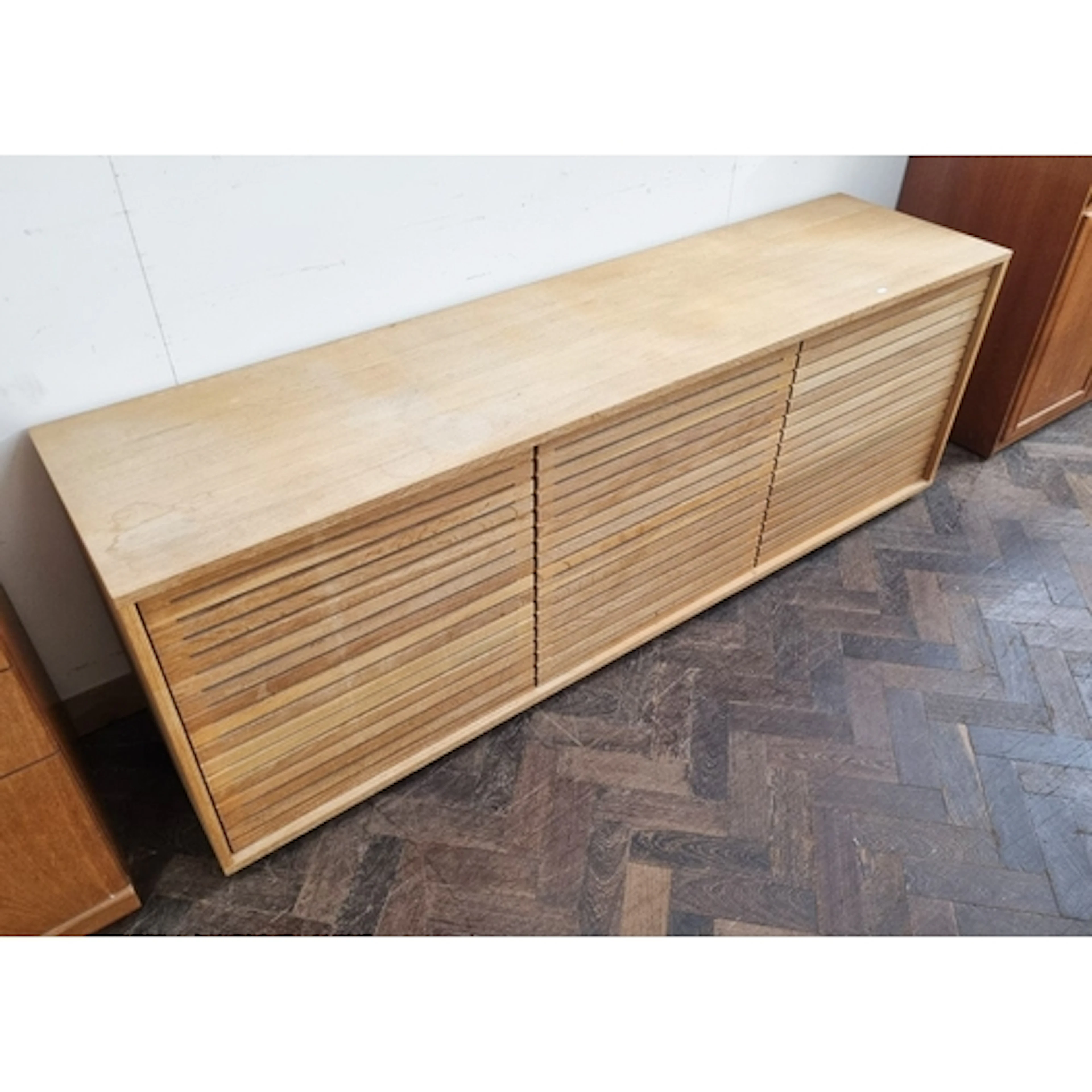 A modern light oak finished low sideboard, fitted three louv...
