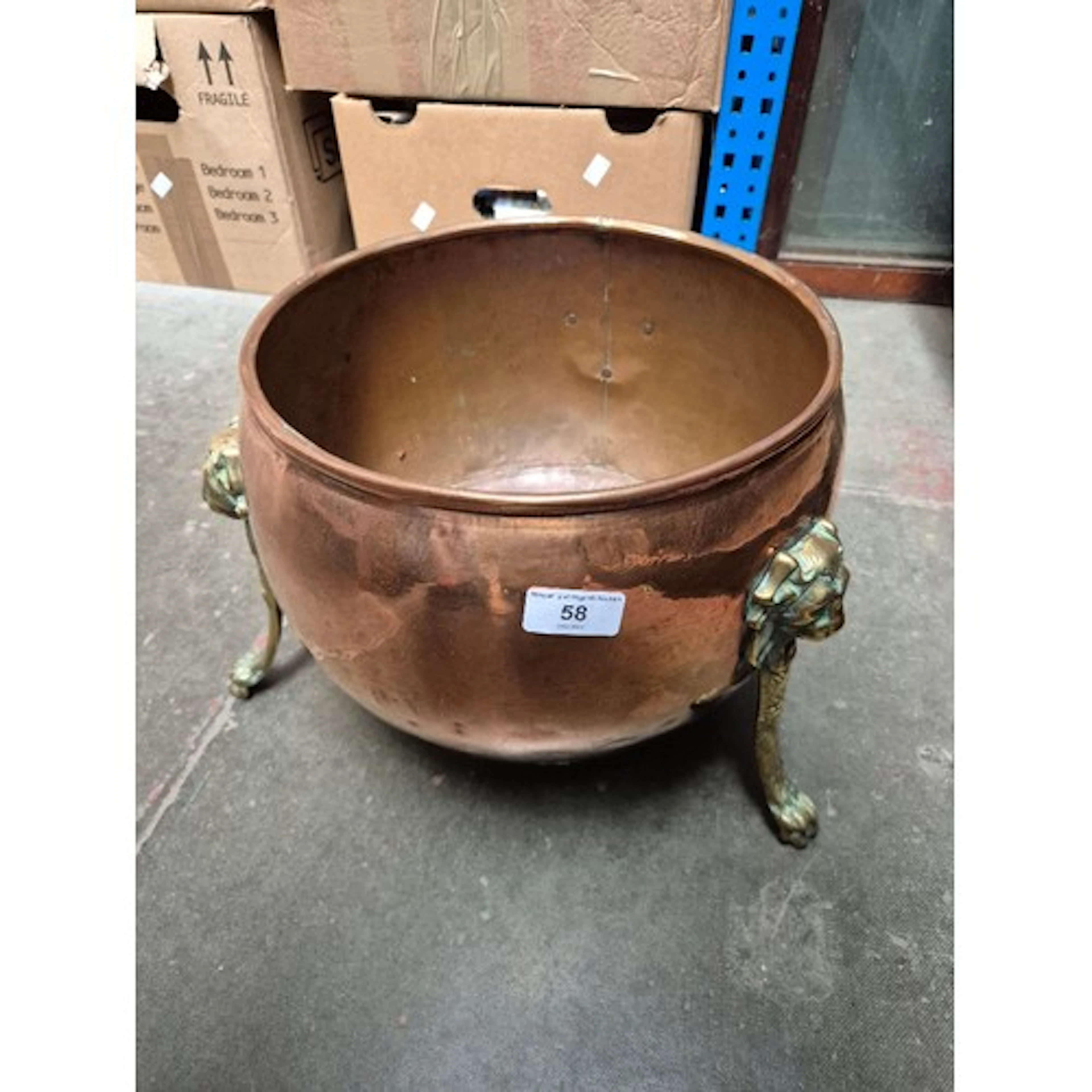 A coper cauldron with brass legs