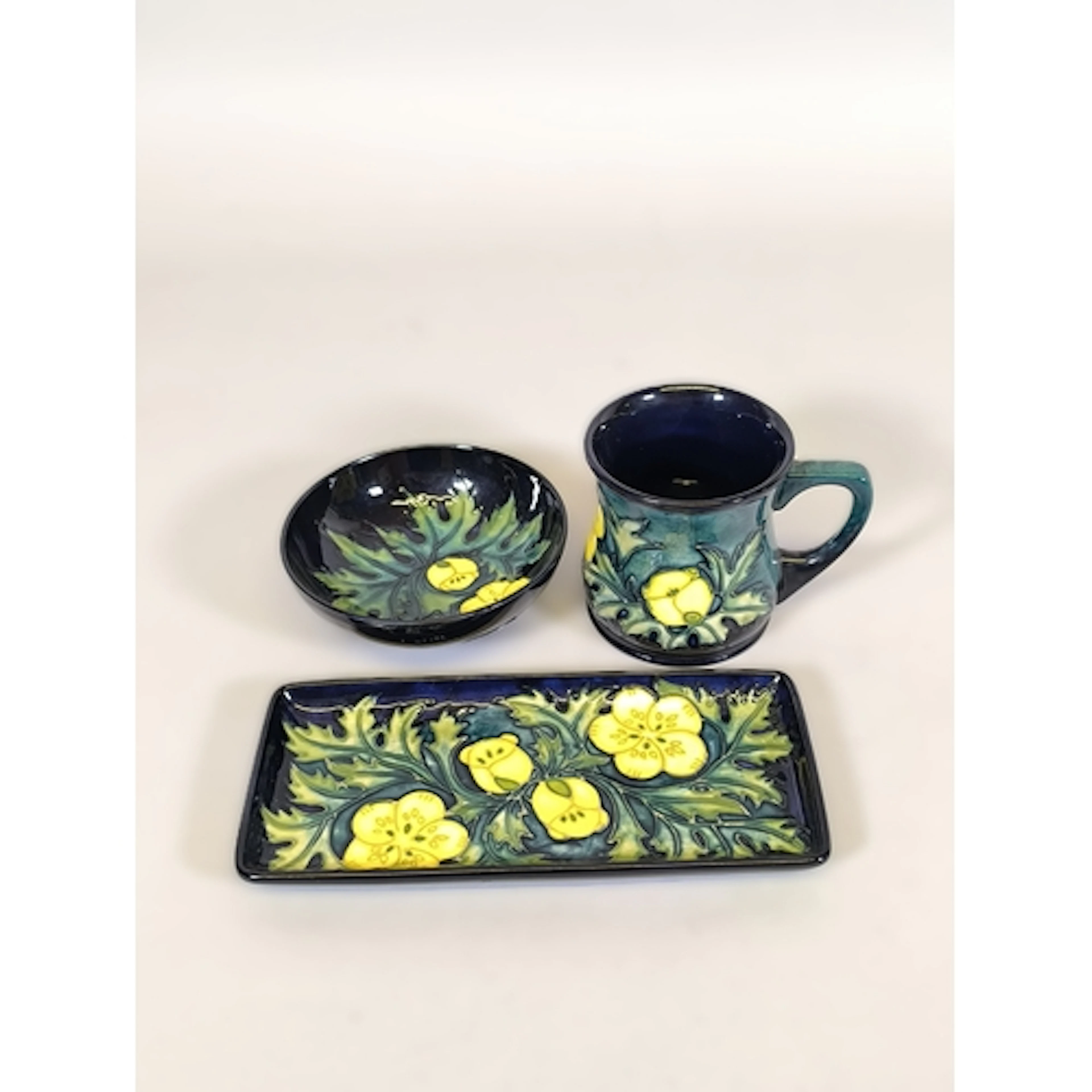 Three pieces of Moorcroft tube lined pottery in the Buttercu...