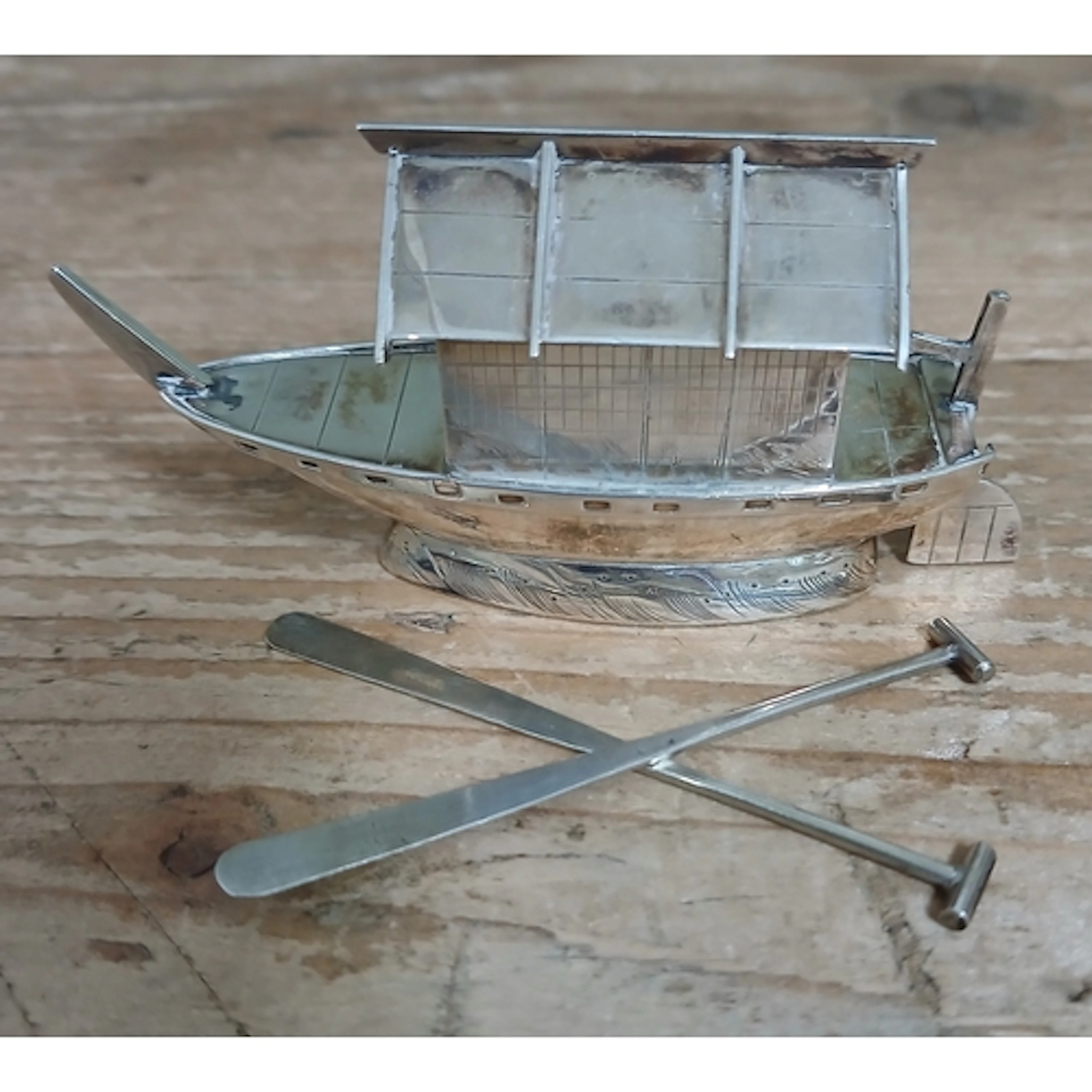 A Japanese export silver pepper pot modelled as a junk boat,...