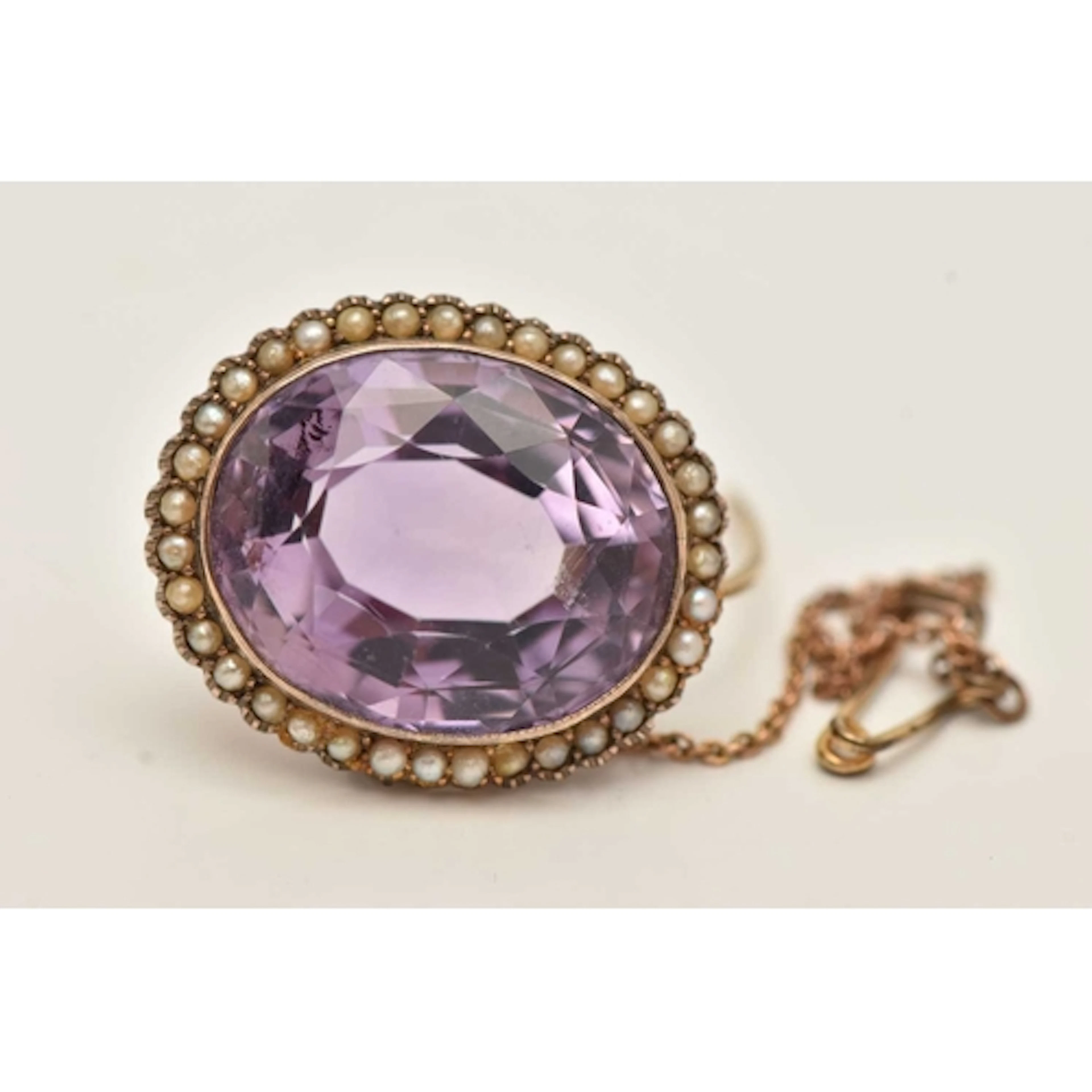 AN EARLY 20TH CENTURY AMETHYST AND SEED PEARL BROOCH, an ova...