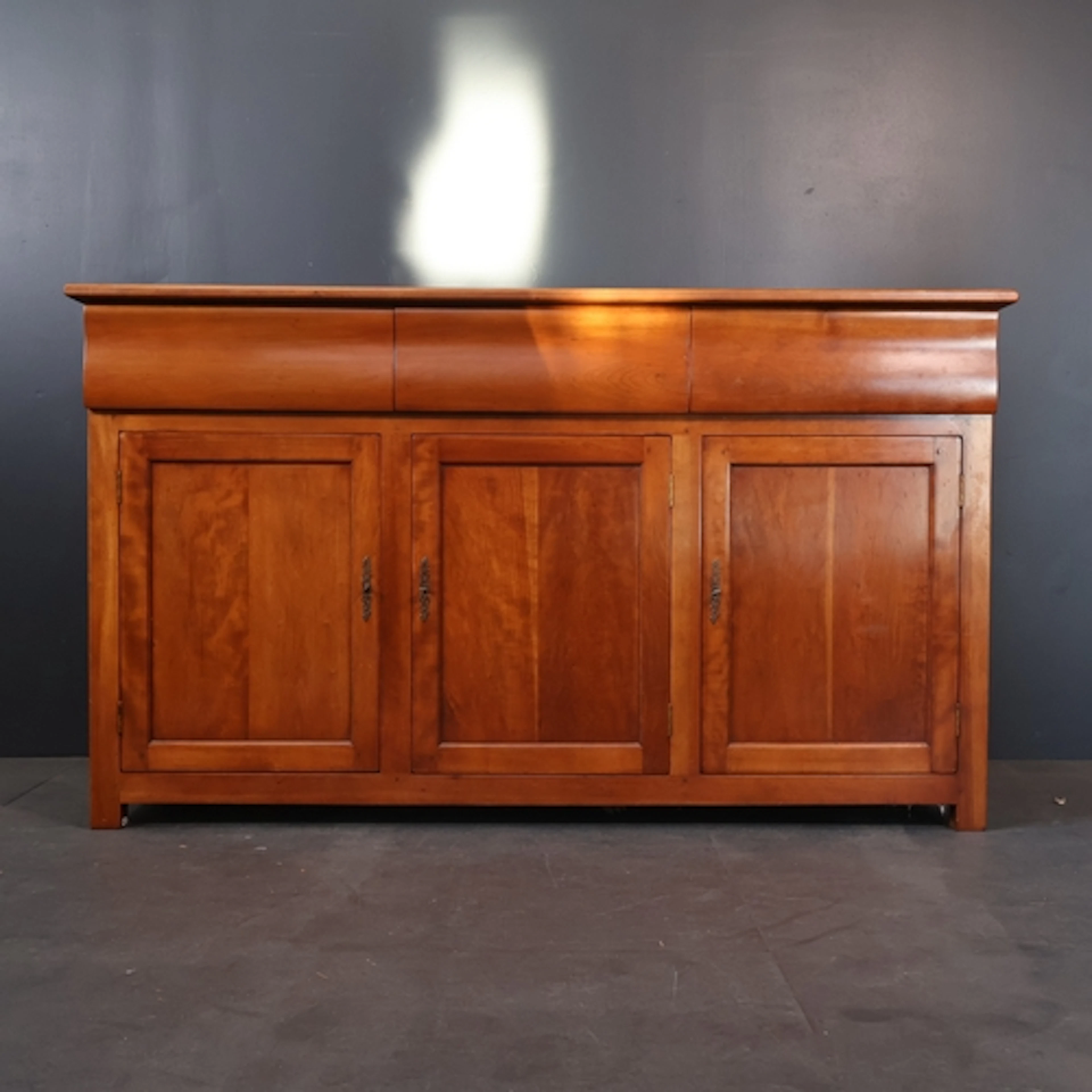 A contemporary craftsman made cherry wood sideboard with thr...
