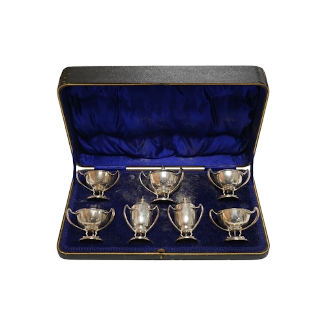 A cased Edwardian Art Nouveau silver seven piece condiment s...