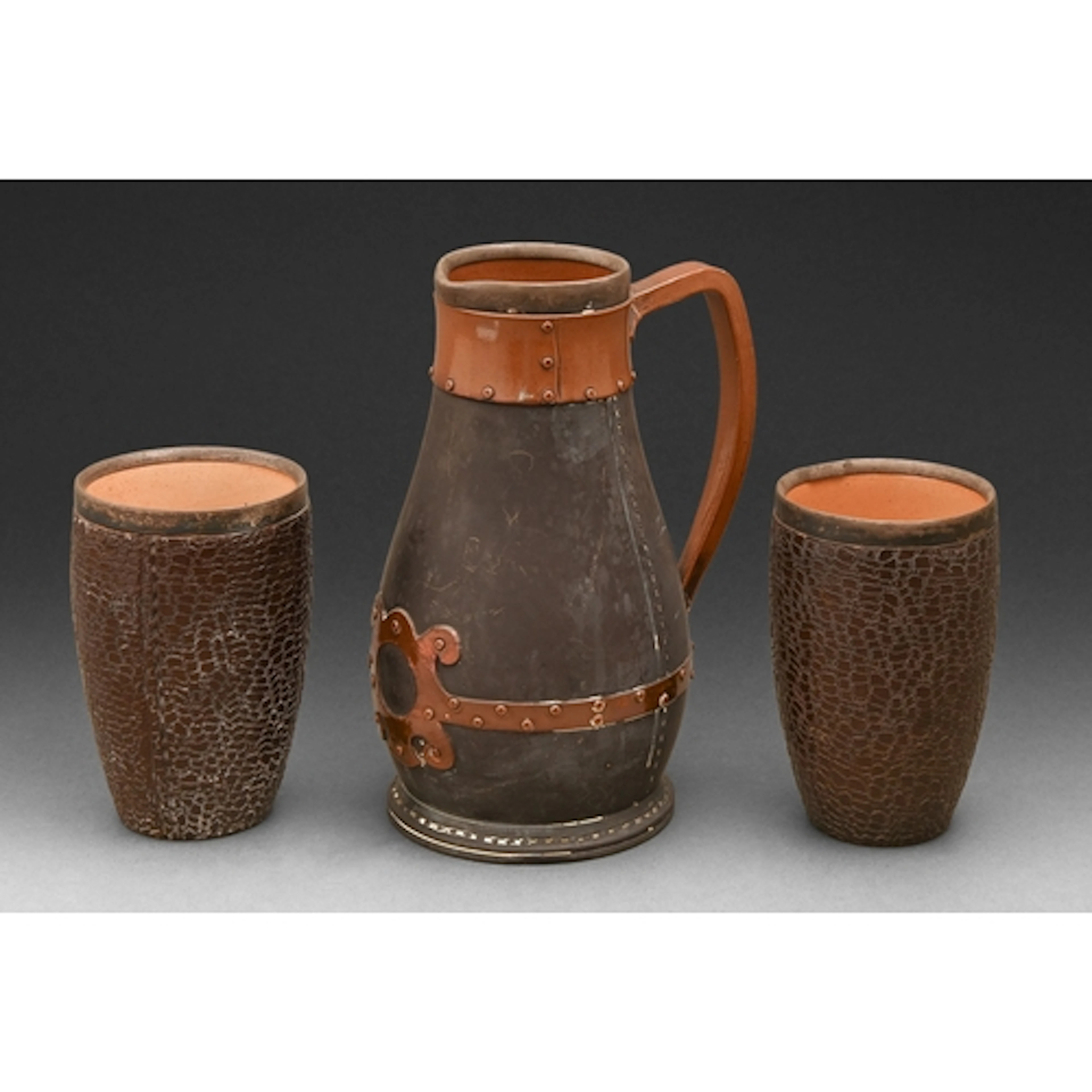 A Doulton ware silver mounted 'copper and black leather' war...