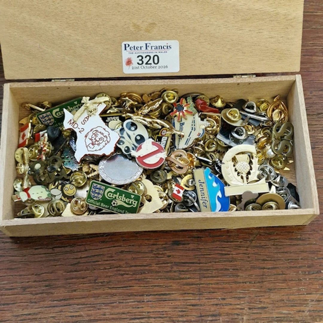 Cigar box comprising a large collection of pin badges to inc...