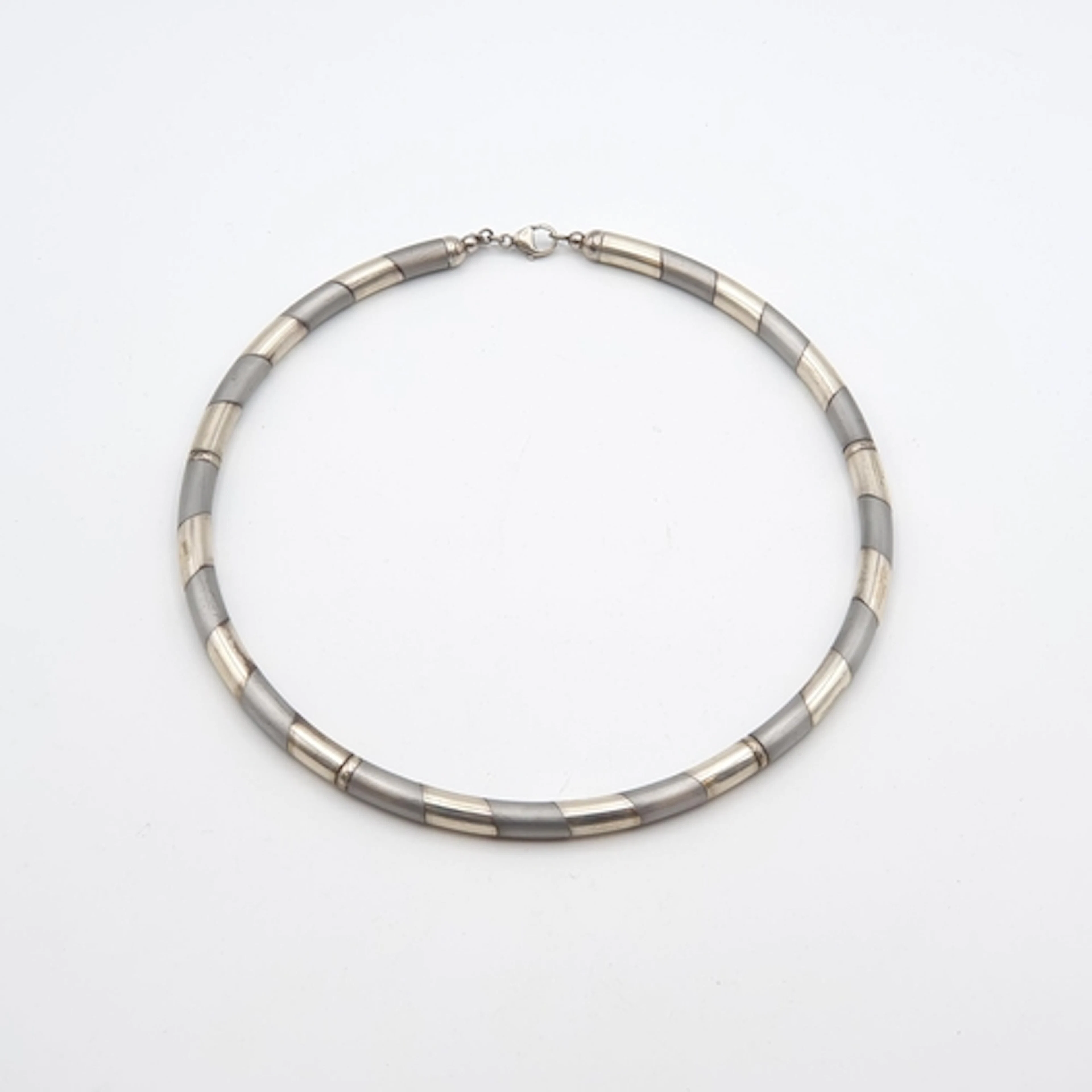 A two silver Necklace of linked tubular sections of two-tone...