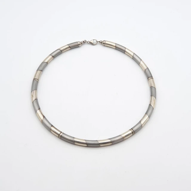A two silver Necklace of linked tubular sections of two-tone...