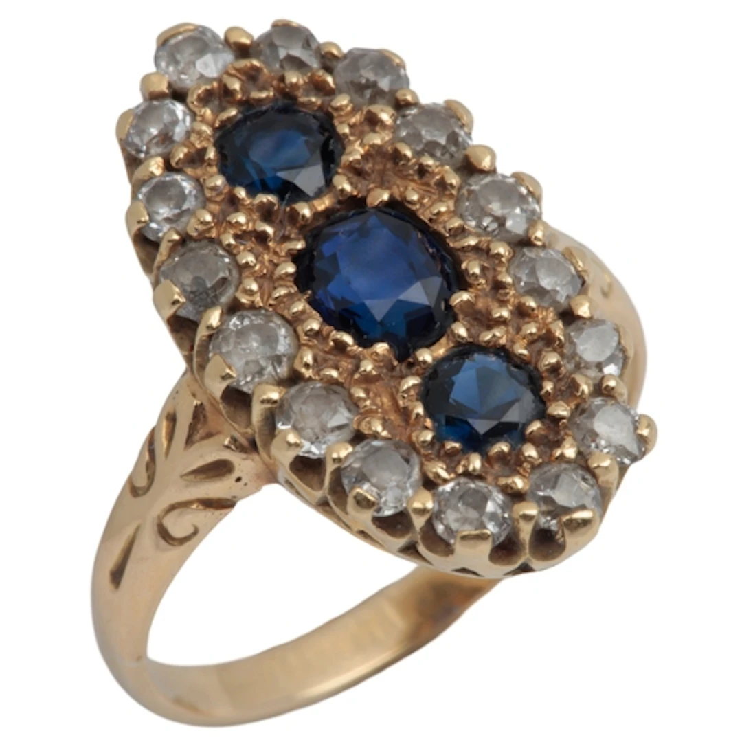 A sapphire and diamond cluster ring, designed as an oval pla...