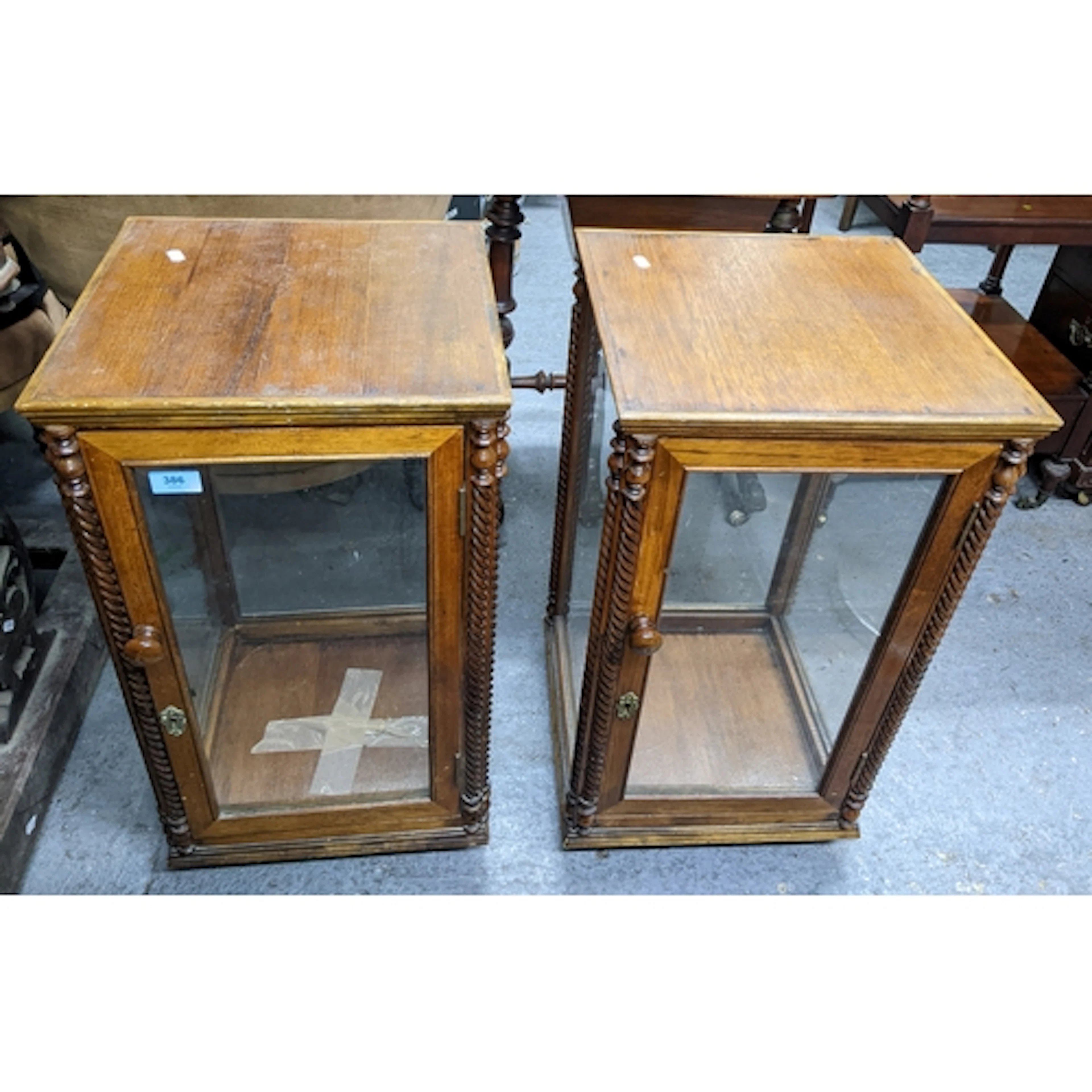 A pair of early 20th century oak display cabinets on swivel ...