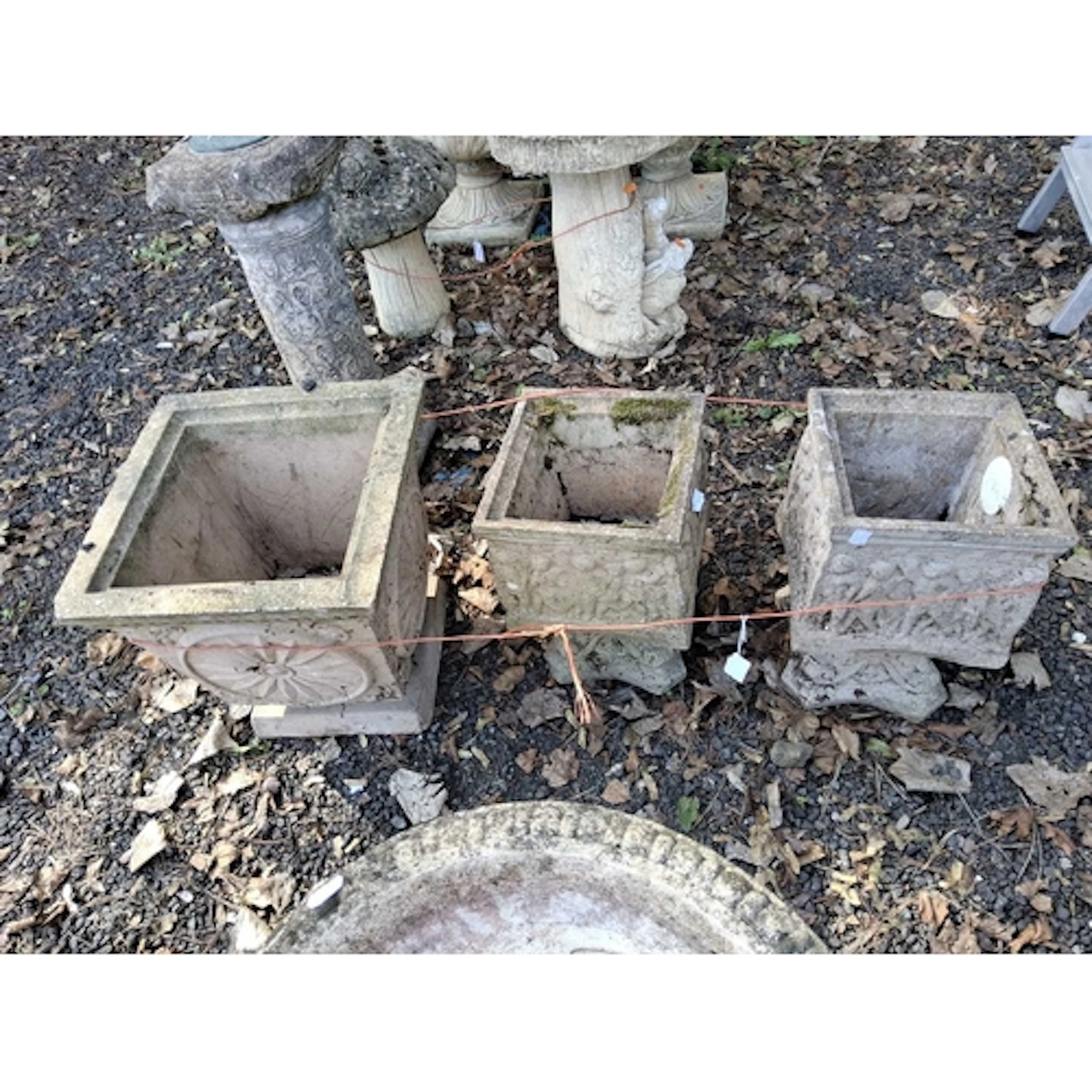 THREE SQUARE CONCRETE PLANTERS ON SEPERATE BASES the largest...