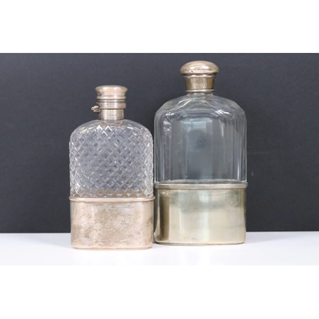 Two sterling silver topped glass hip flasks with cut glass d...