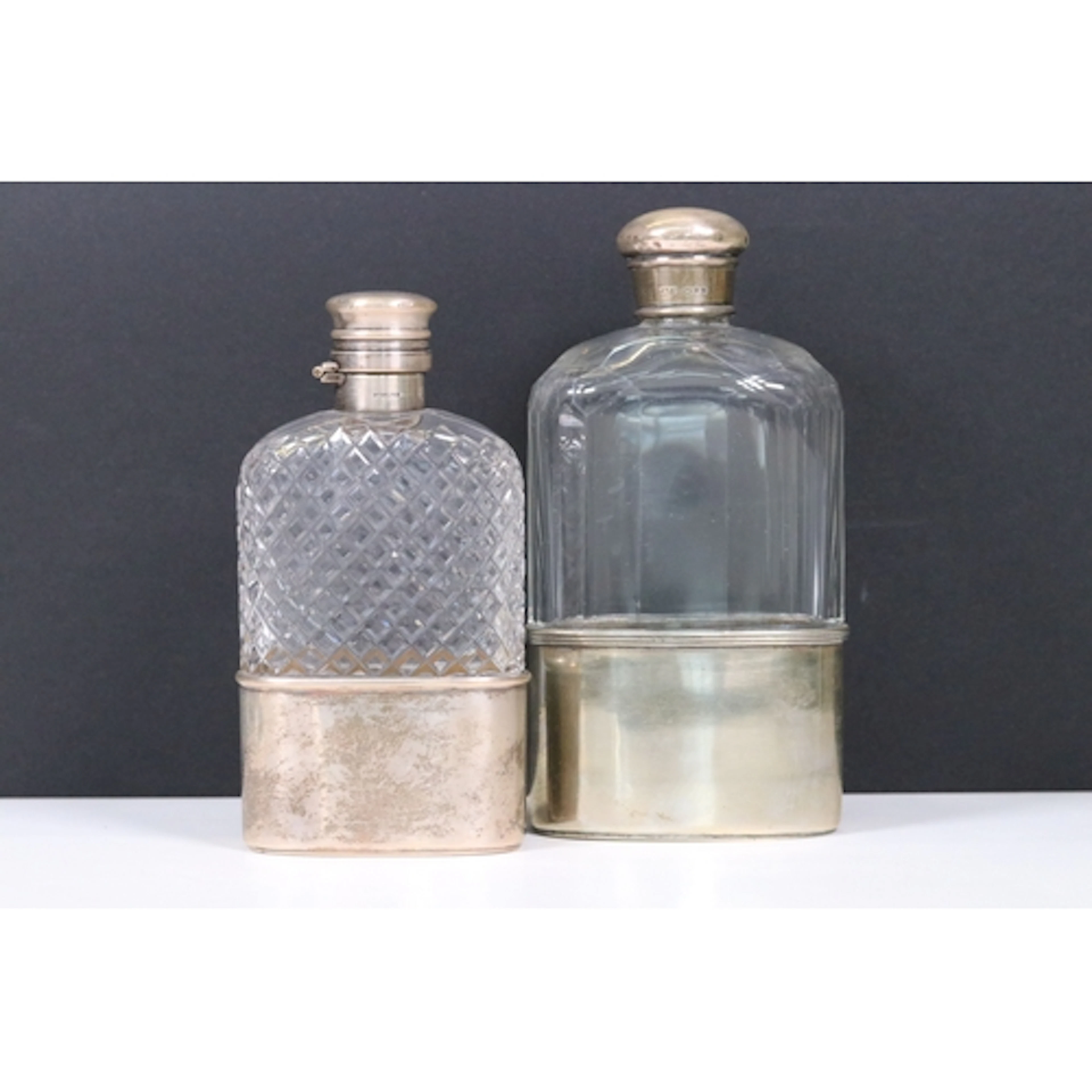 Two sterling silver topped glass hip flasks with cut glass d...